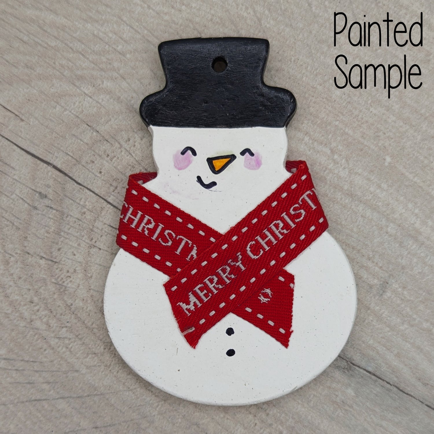 Painted snowman decoration with a red 'Merry Christmas' ribbon scarf