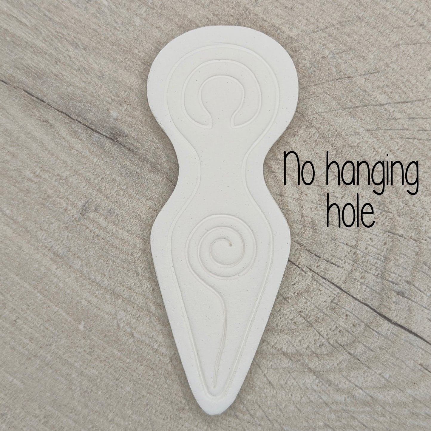 Spiral goddess shaped clay decoration shown on a light wood background, with wording no hanging hole