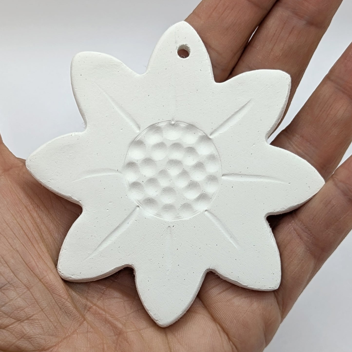 air dried clay decoration displayed in palm of a hand
