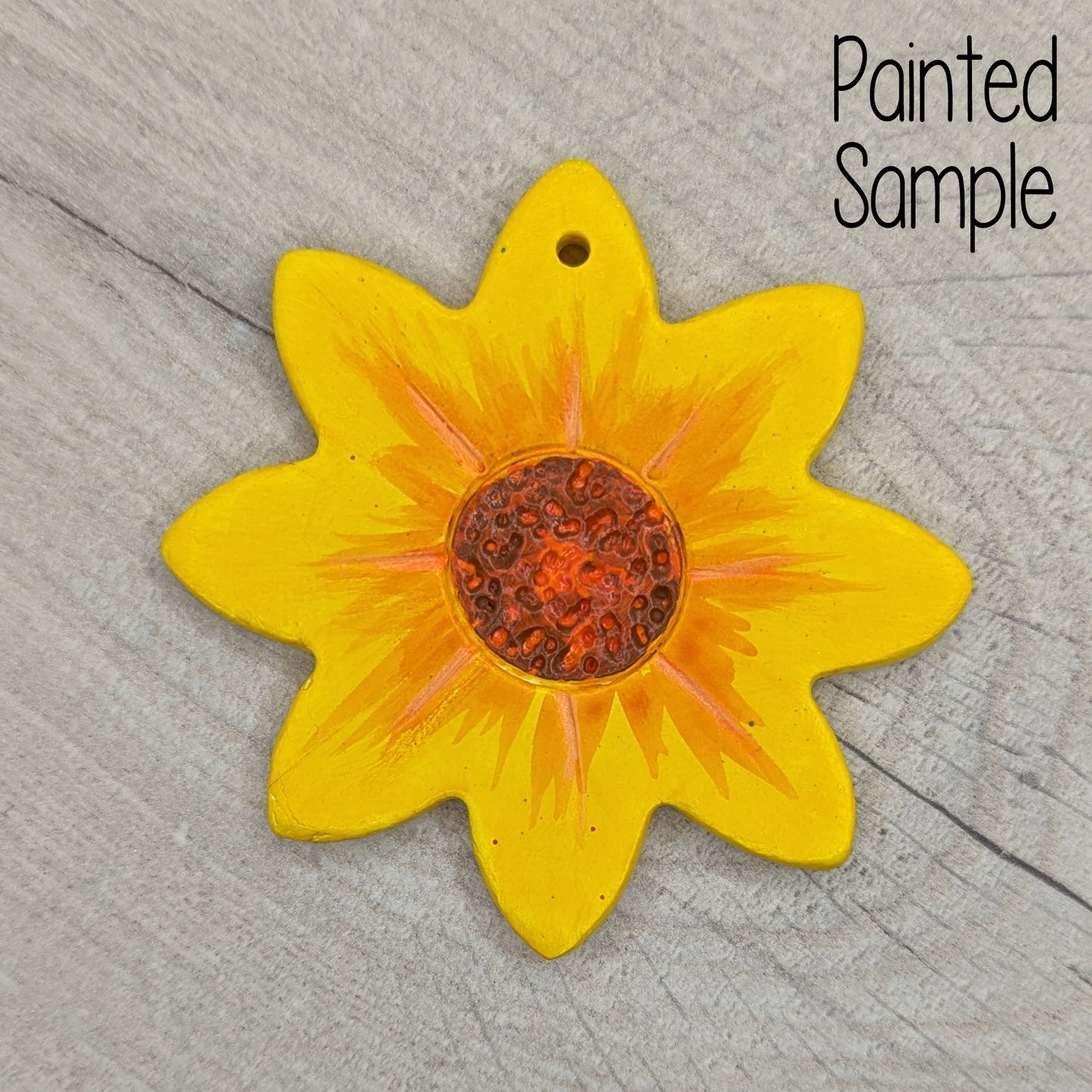 painted clay sunflower decoration, painted with yellow petals and a brown centre