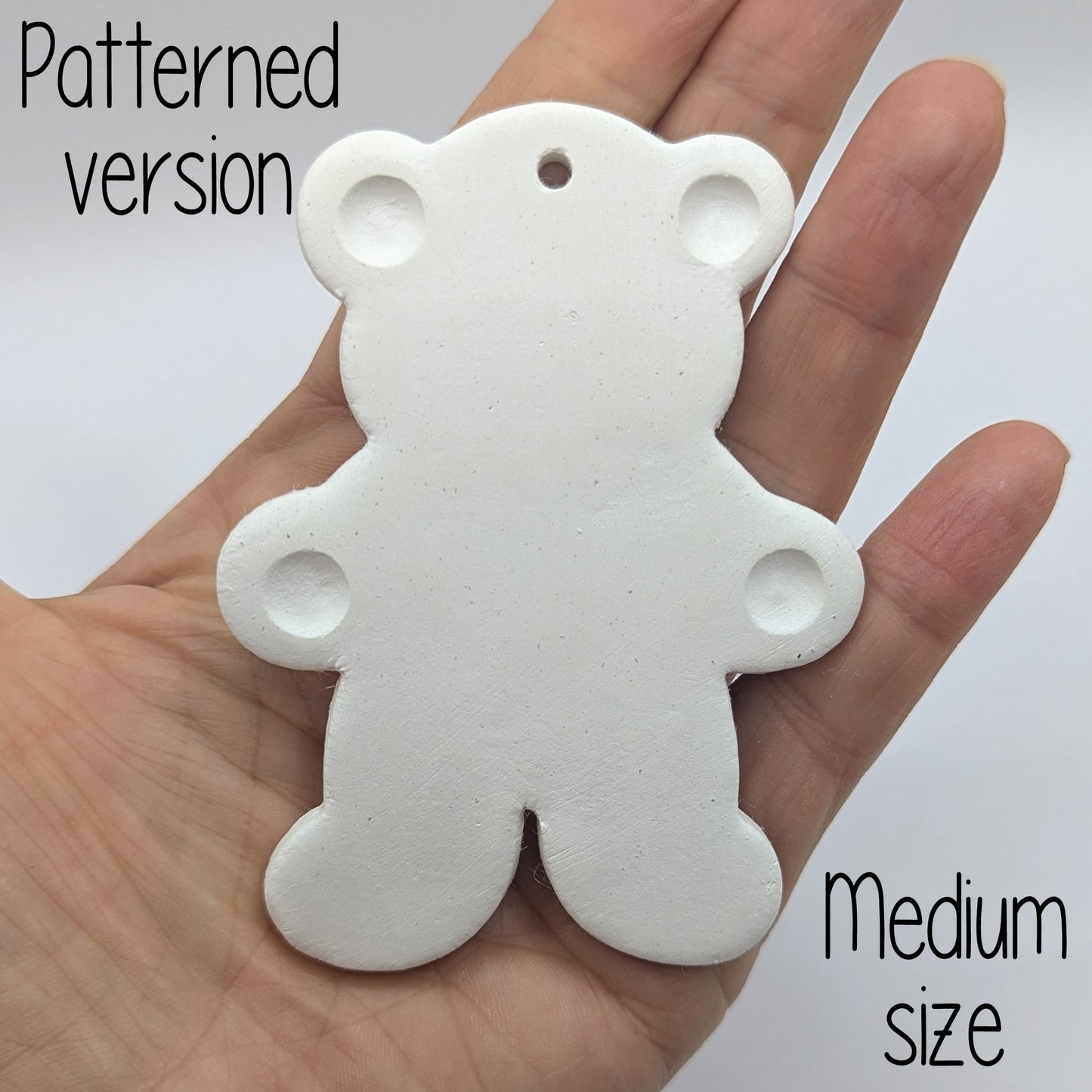 White clay decoration in the shape of a teddy bear with ears and paws stamped on
