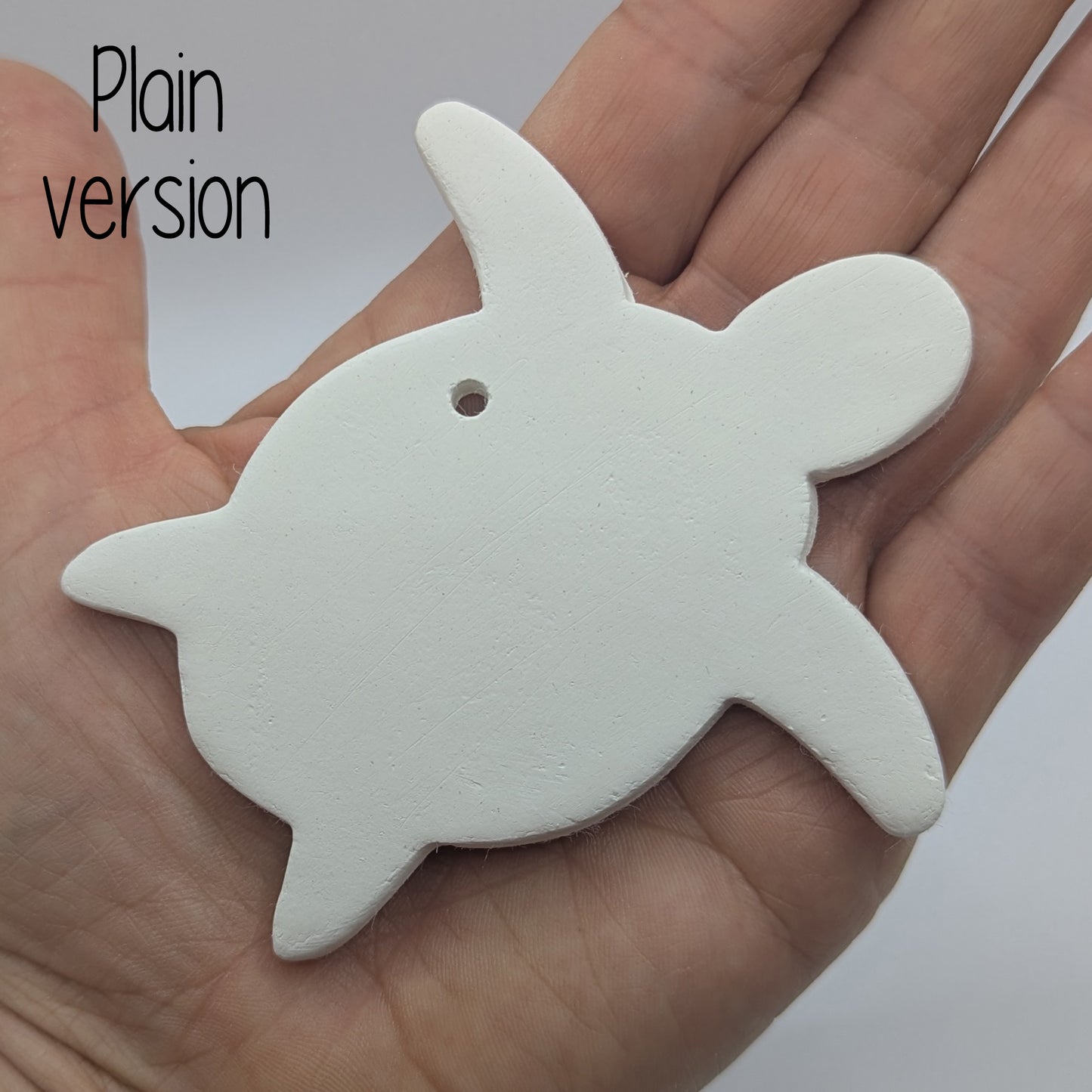 clay shaped turtle decoration in some ones hand to show scale