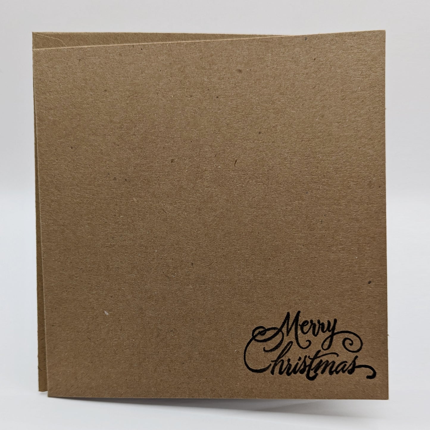 merry Christmas, stamped in black ink onto a kraft card comes with matching envelope