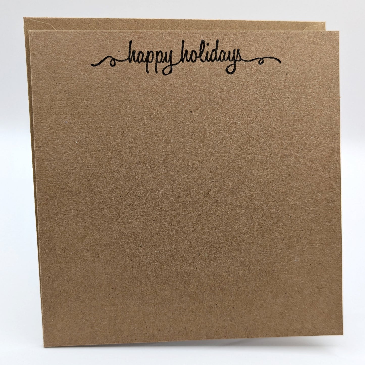 happy holidays stamped in black ink onto a kraft card, comes with envelope
