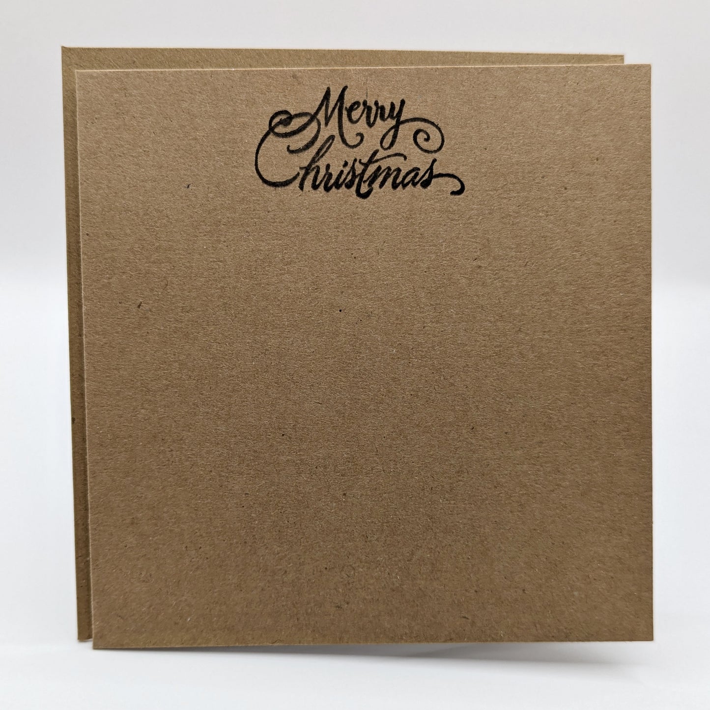 merry Christmas, stamped in black ink onto a kraft card comes with matching envelope