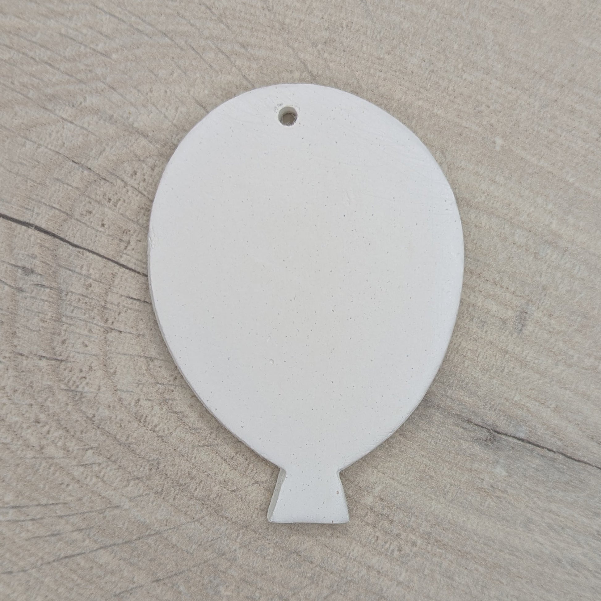 White clay balloon decoration / tag / ornament on wooden background