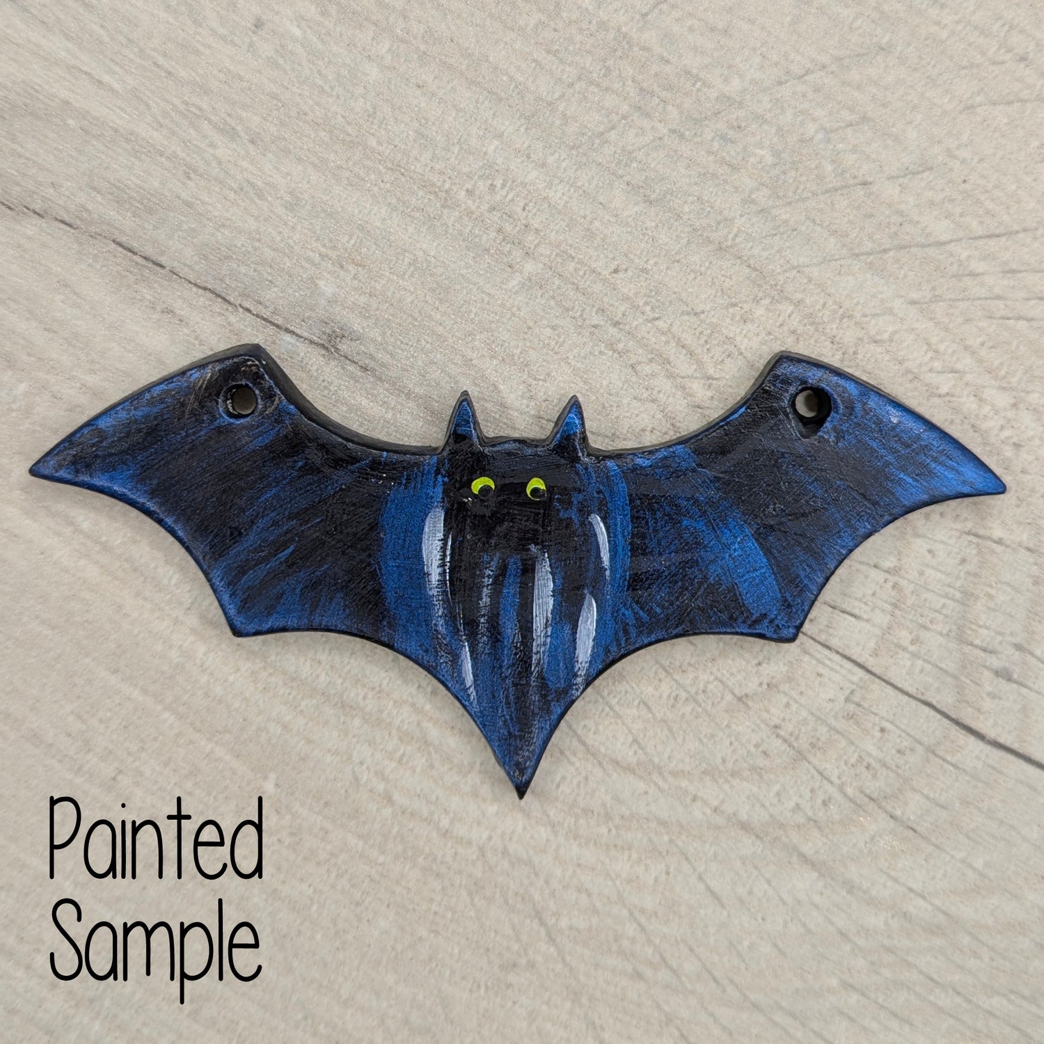painted bat in black and blue on light wood background
