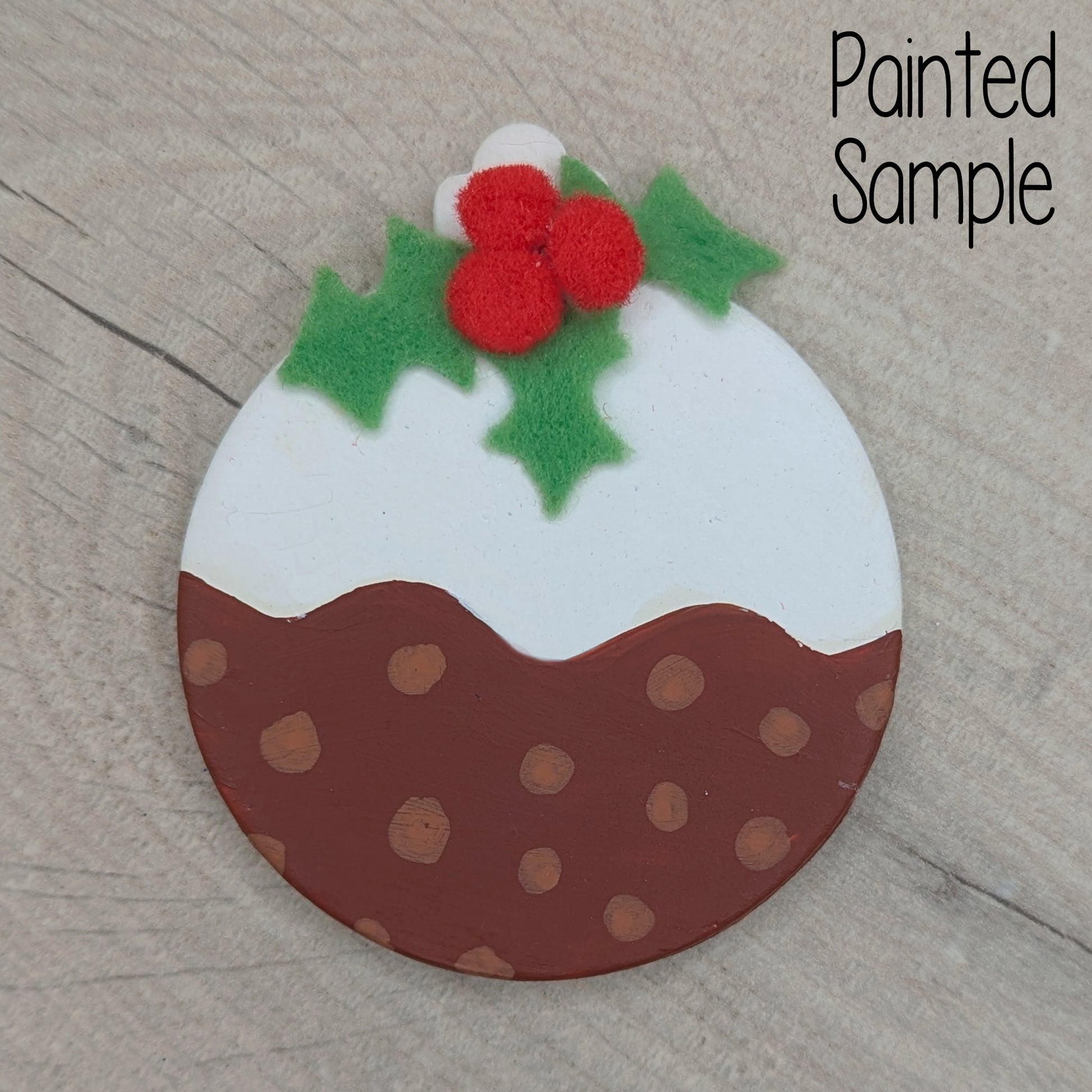 sample clay bauble, painted like a Christmas pudding with green felt holly and red mini pom poms