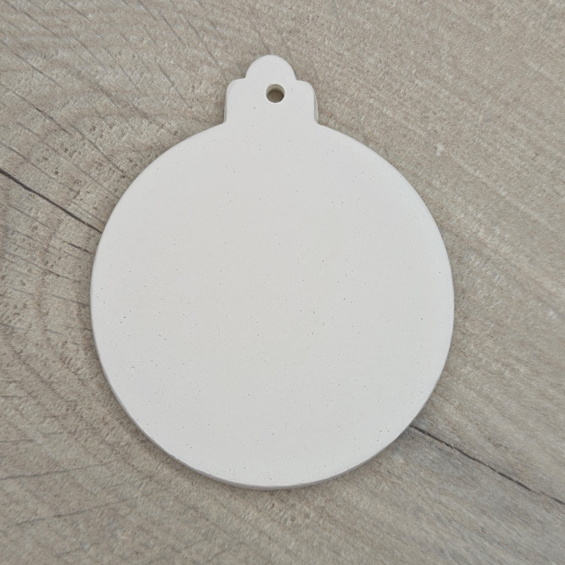 white clay bauble decoration, for Christmas time on wooden background