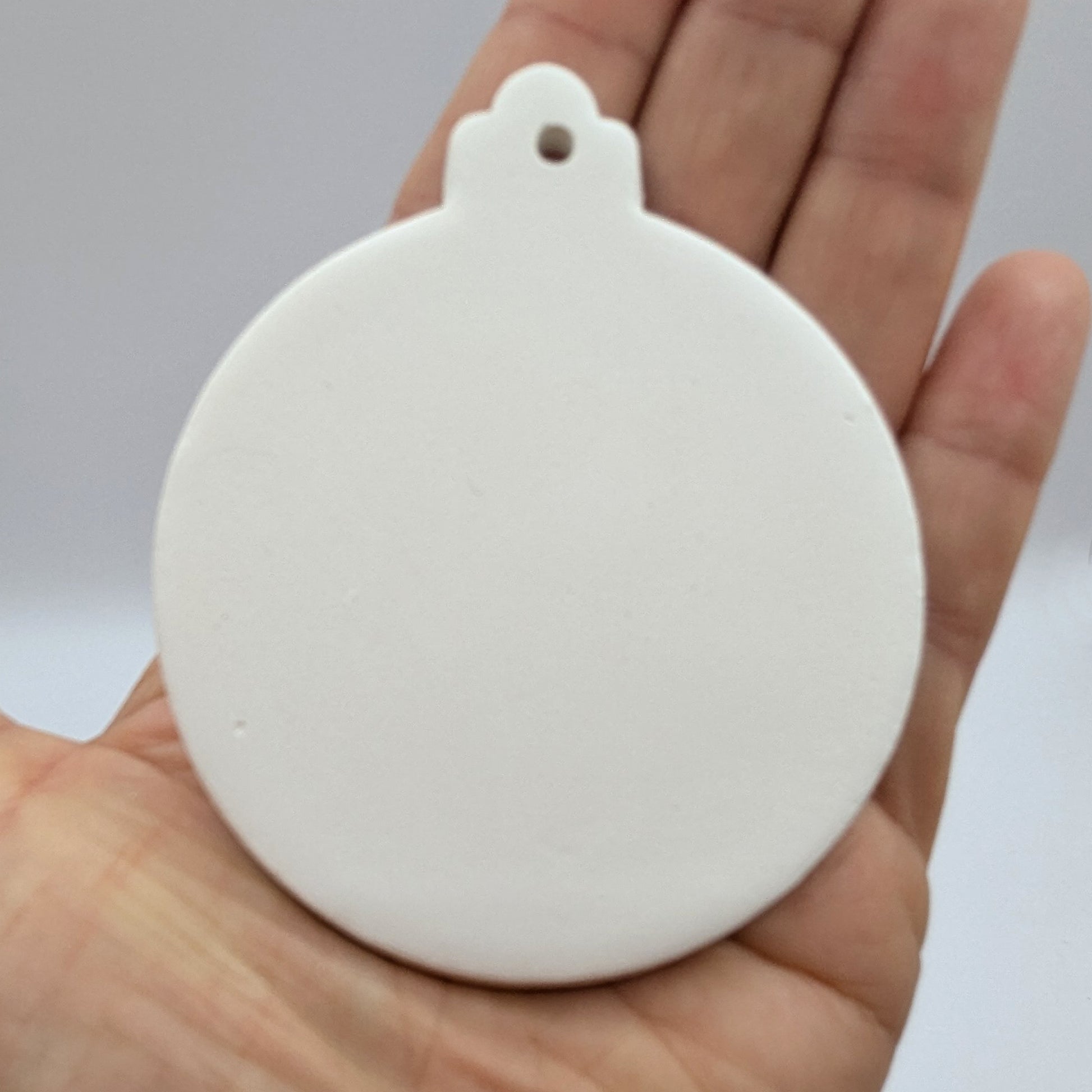 White round bauble decoration held in a hand