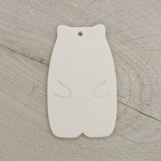 White clay abstract shaped bear on a wooden surface