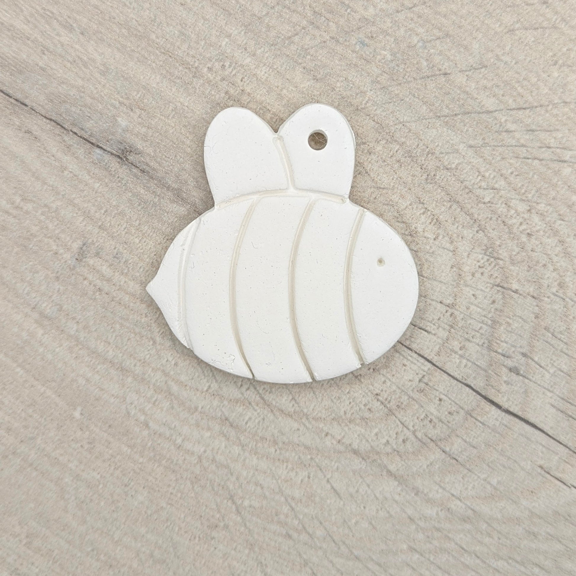 white air dried clay been decoration on a light wooden background