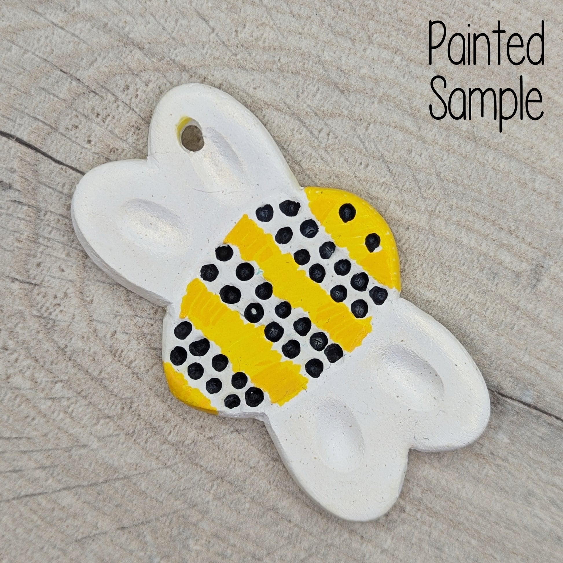 bumble bee clay decoration painted in yellow and black paint with iridescent gold on the wings