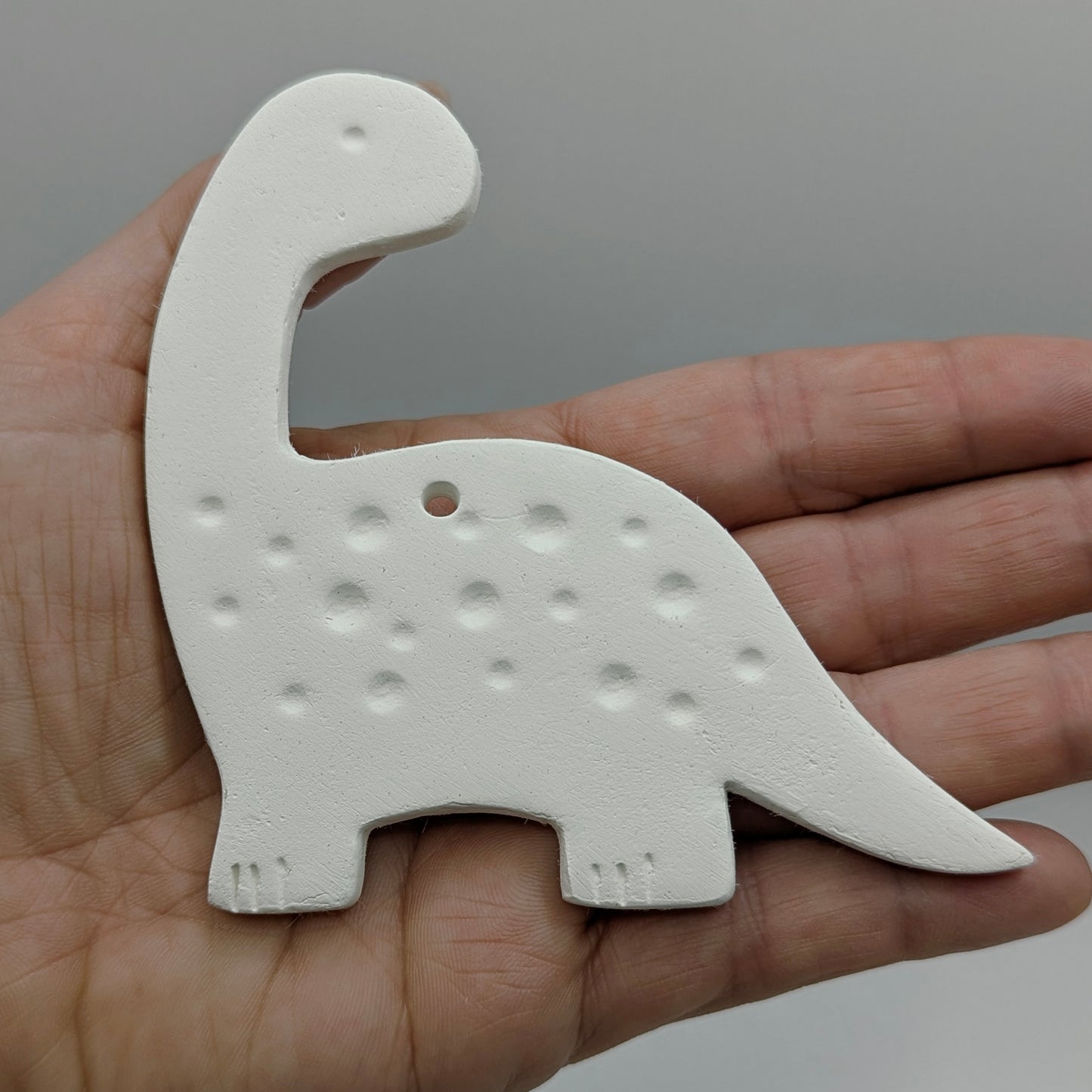 diplodocus shaped white clay decoration