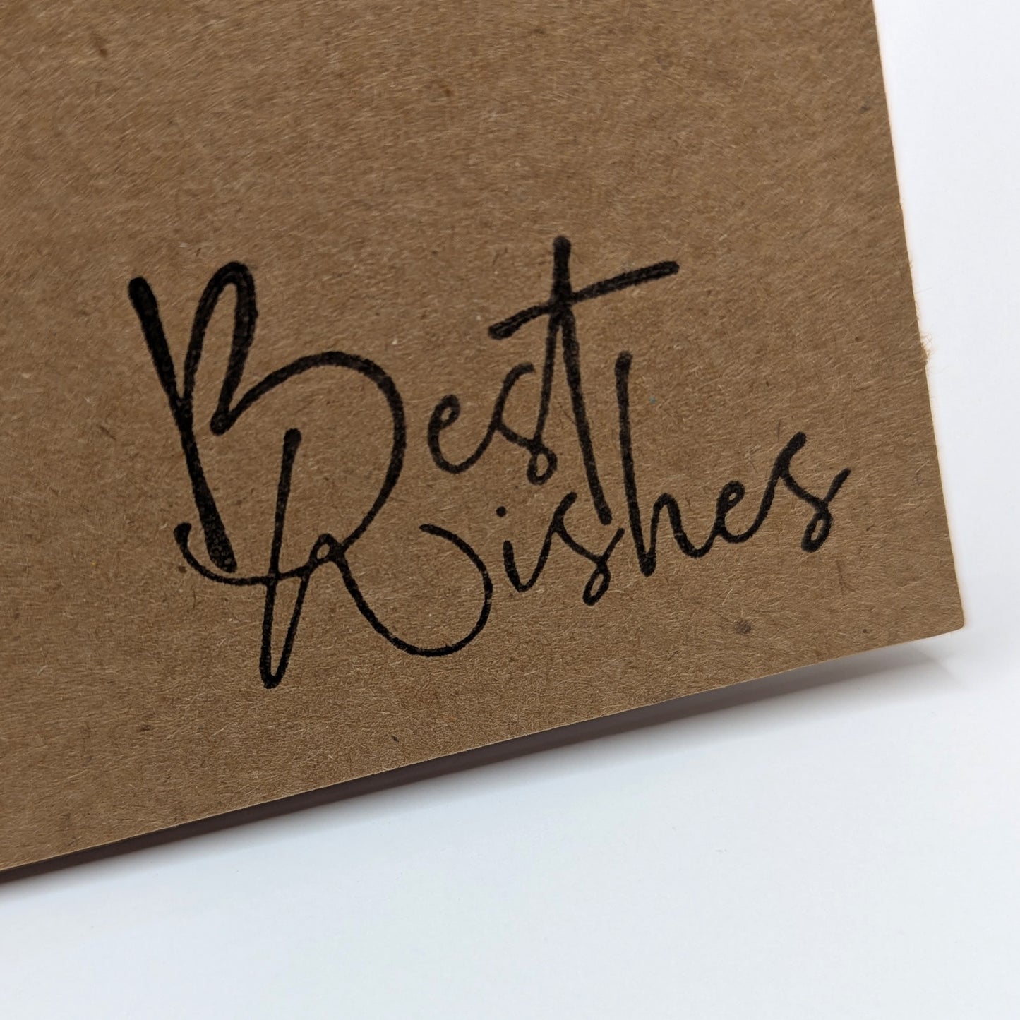 best wishes stamped onto the corner of a kraft card