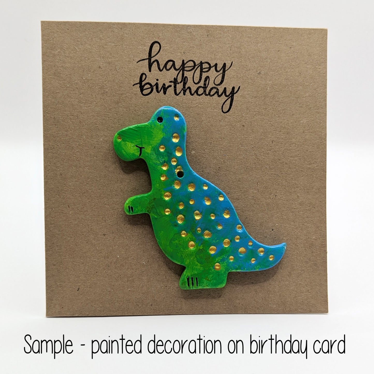happy birthday card with a painted clay dinosaur on the front in green and blue