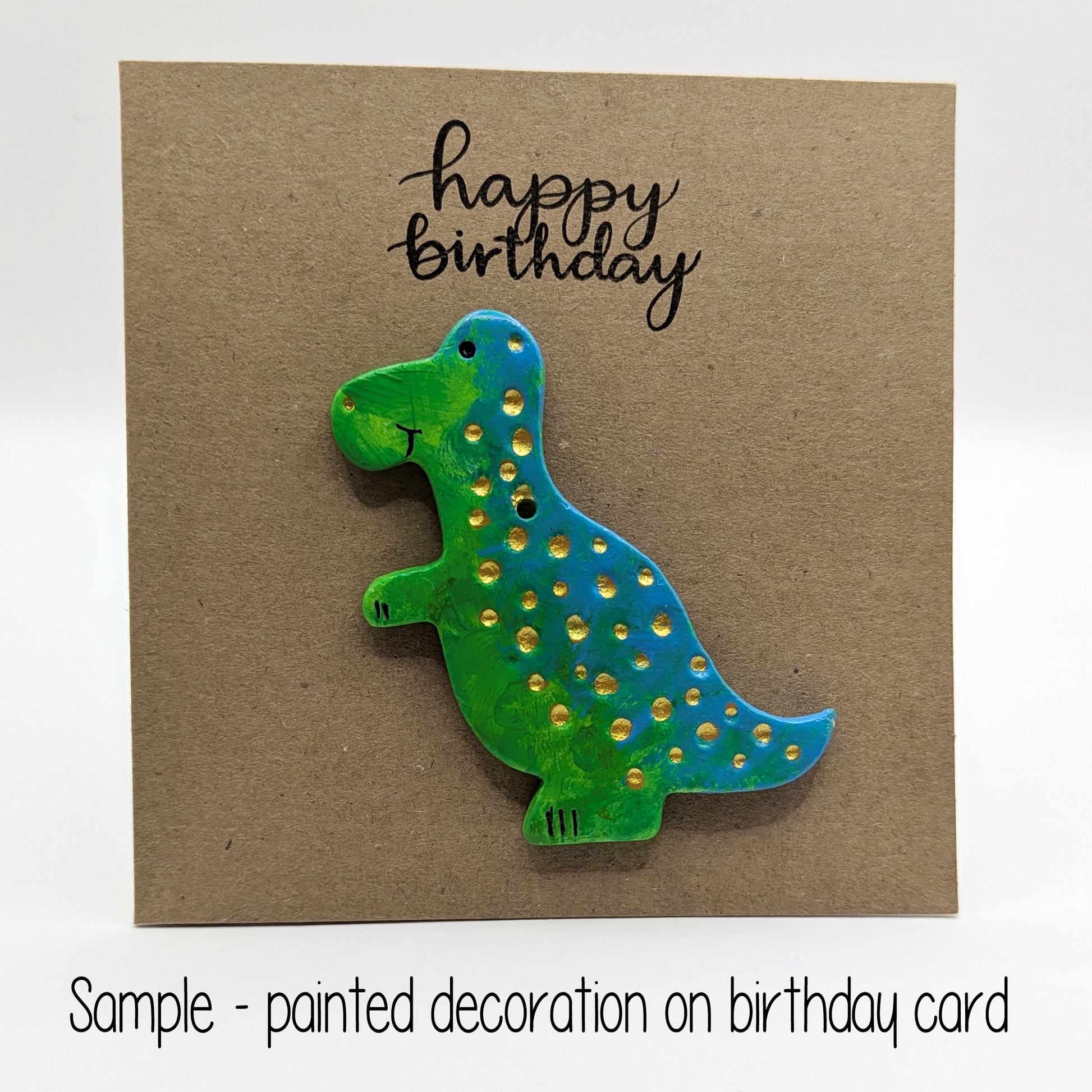 happy birthday card with a painted clay dinosaur on the front in green and blue