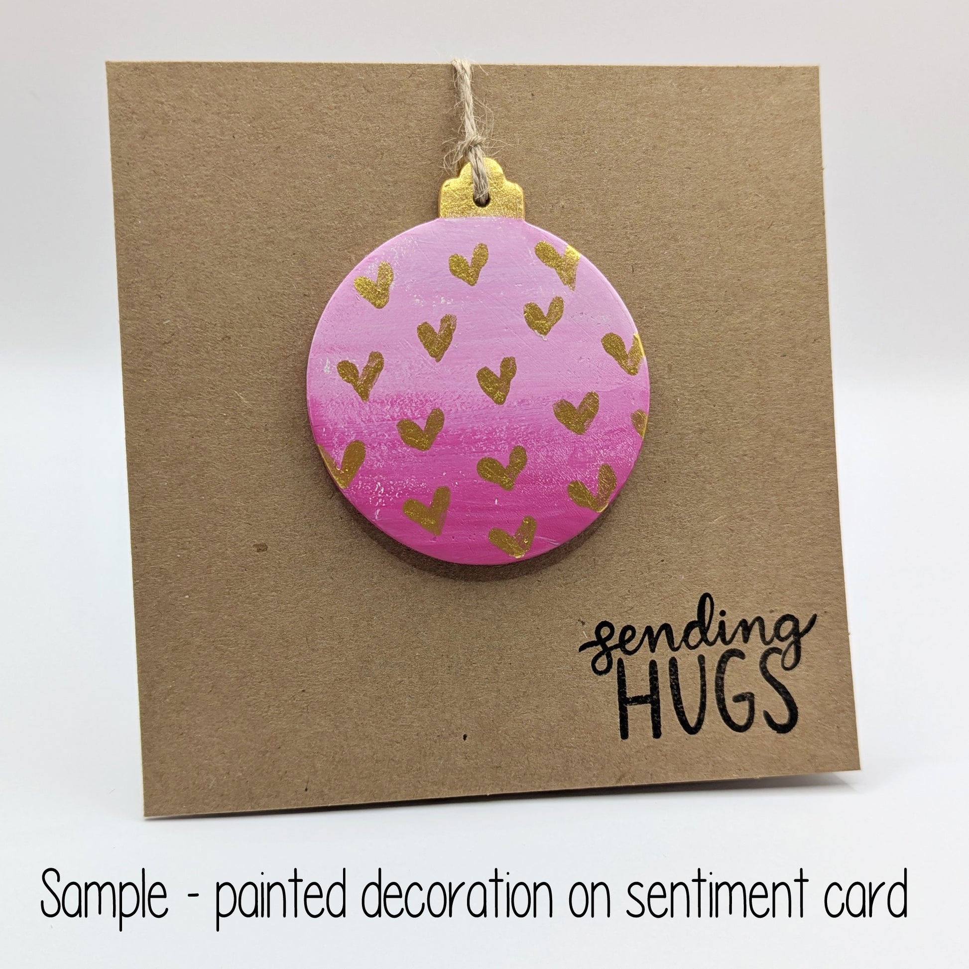 sending hugs card with a pink bauble clay decoration attached to the front, bauble has gold hearts on it