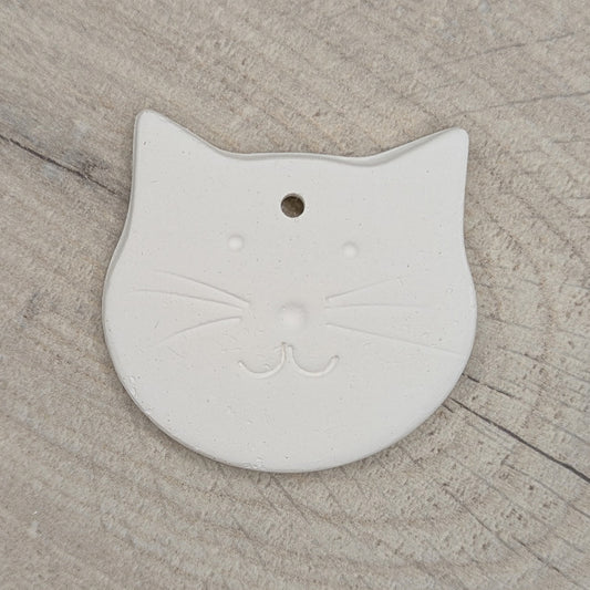 small cute cat face shaped clay decoration with a cat face stamped into it to paint and decorate