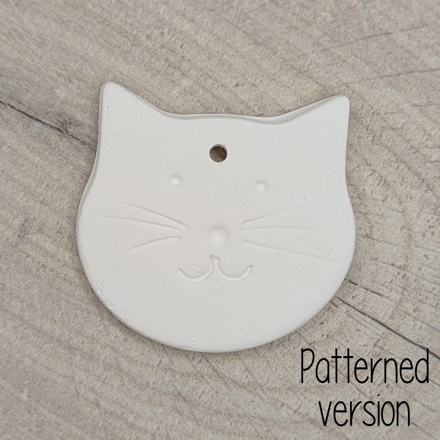 small cute cat face shaped clay decoration with a cat face stamped into it to paint and decorate