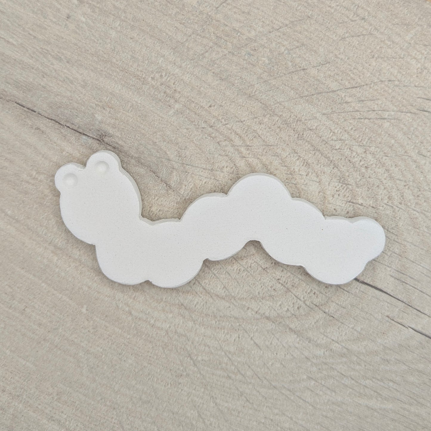 caterpiller clay decoration on a light wood background