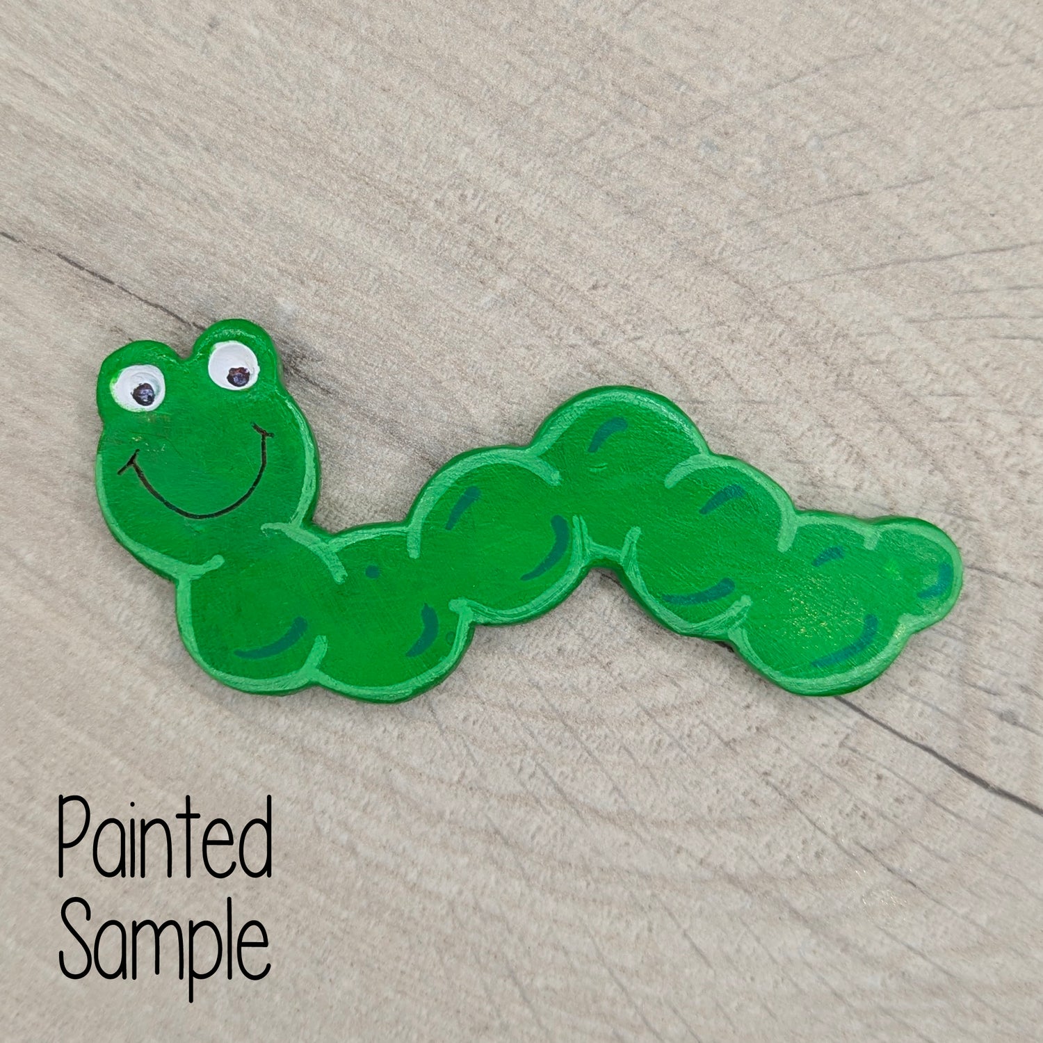 Green caterpillar-shaped decoration with a happy smile