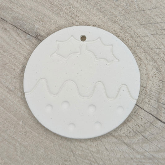 round christmas pudding shaped clay decoration to paint yourself on a wooden background
