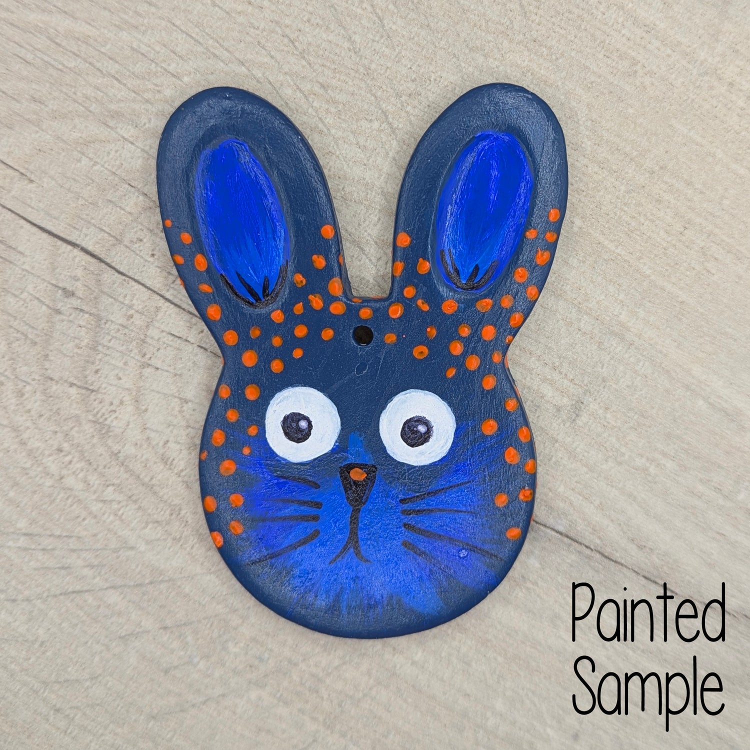 Halloween inspired painted clay rabbit decoration on a wooden background