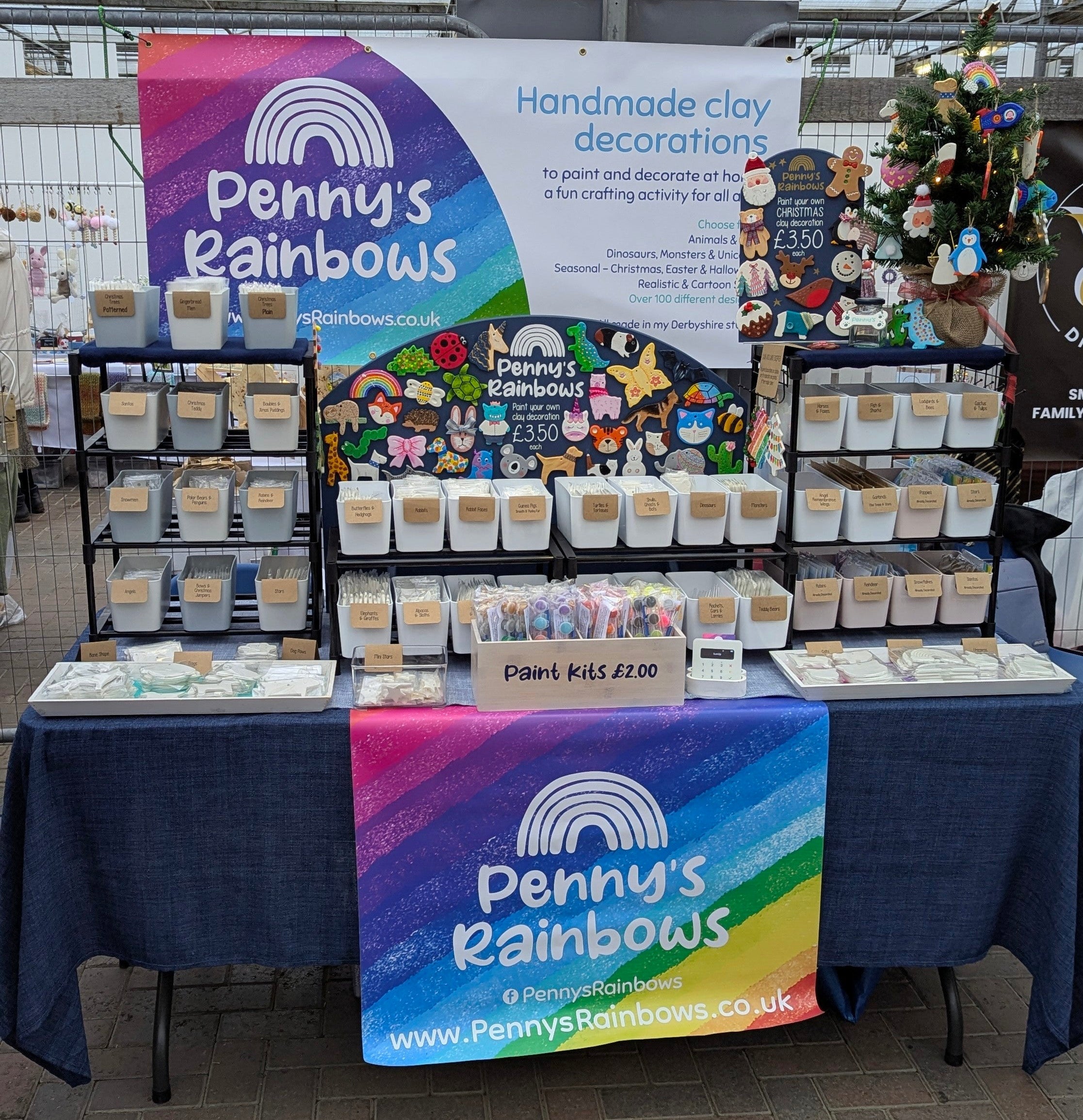 craft fair photo from christmas 2025, table of stock with large penny's rainbows banners 