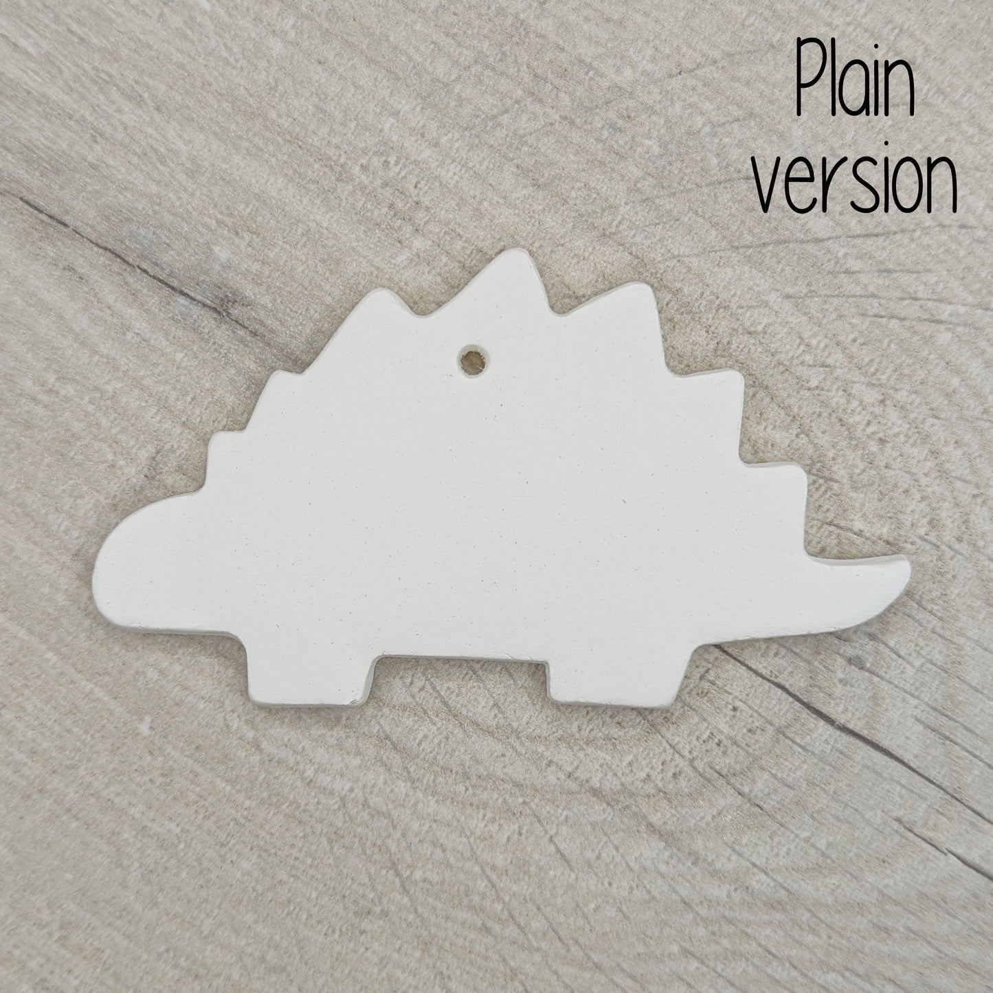 plain Stegosaurus dinosaur air dried clay decoration, for children and adults to paint at home, on wooden background