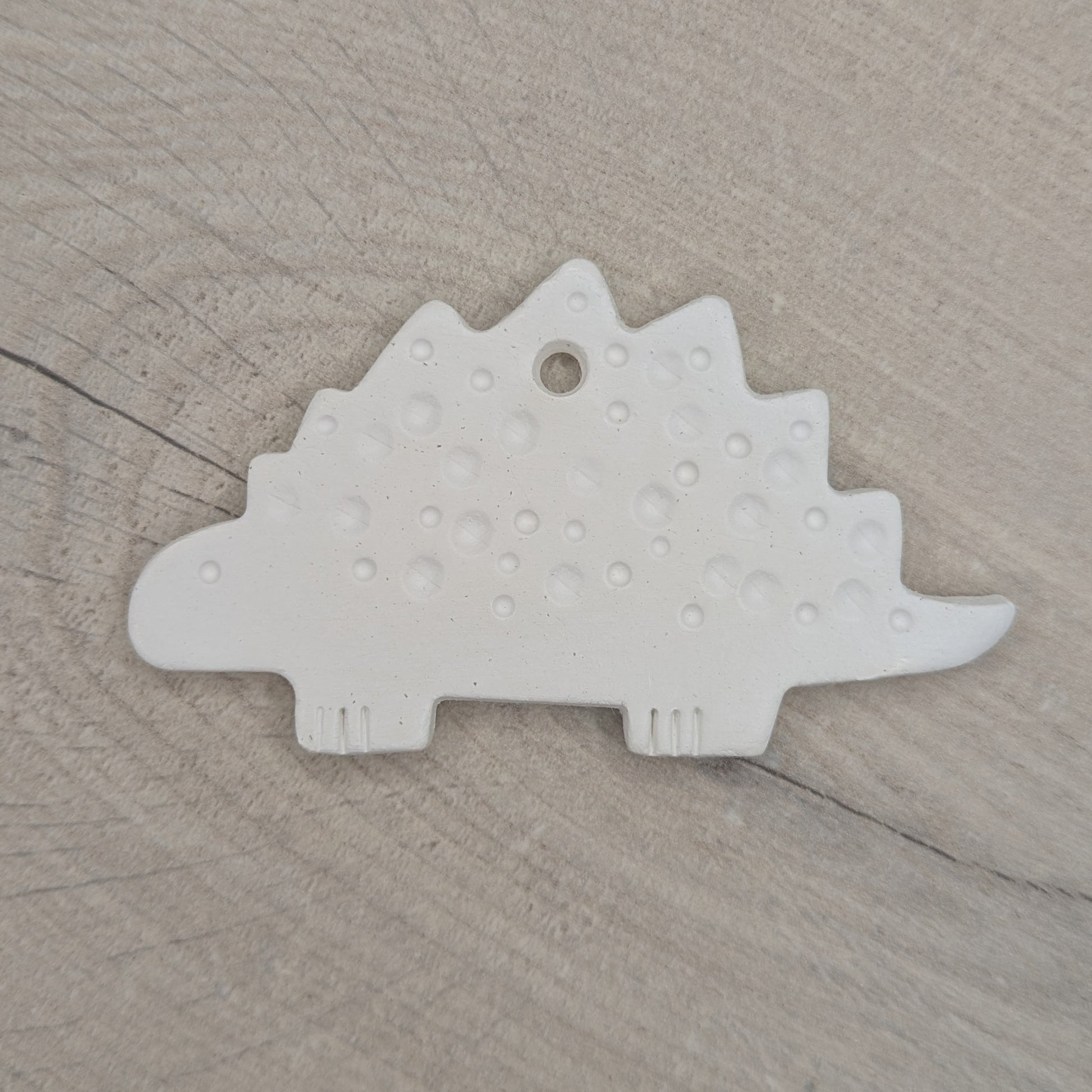 spotted Stegosaurus dinosaur air dried clay decoration, for children and adults to paint at home