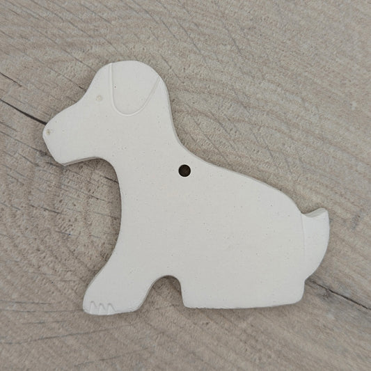 White clay Labrador sitting dog shape on a wooden surface