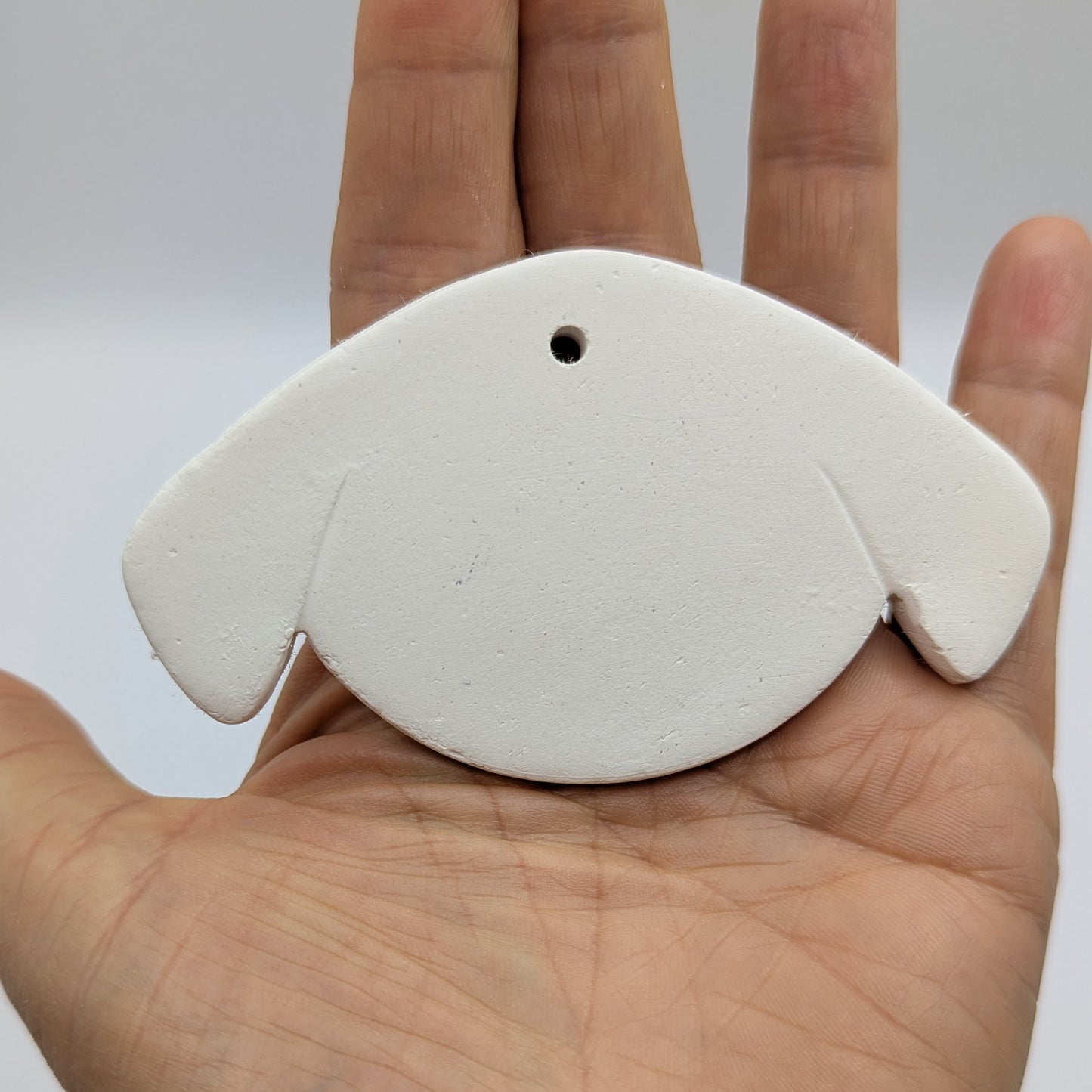 stylised dog face clay decoration to paint and decorate in your own home, dog has floppy ears