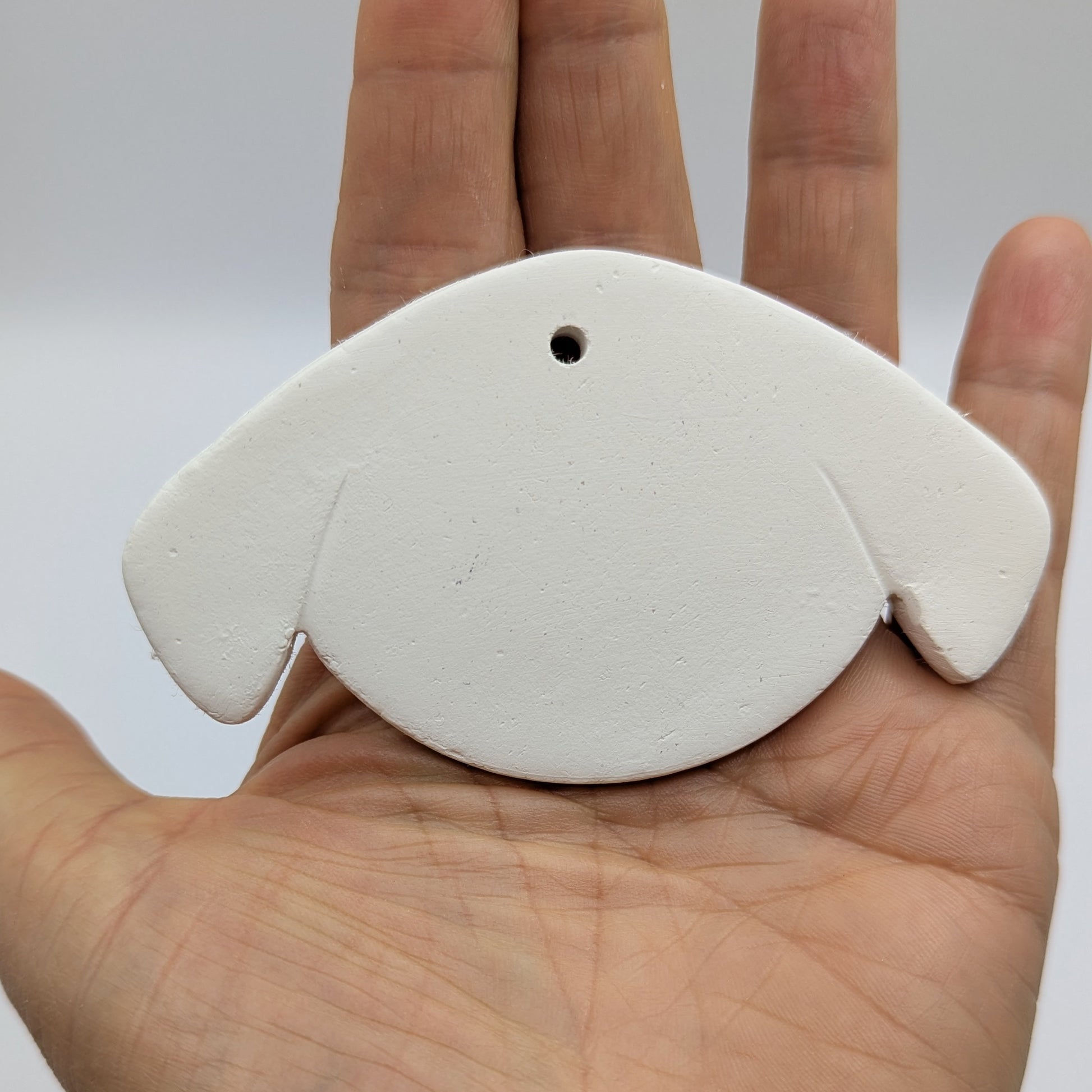 stylised dog face clay decoration to paint and decorate in your own home, dog has floppy ears