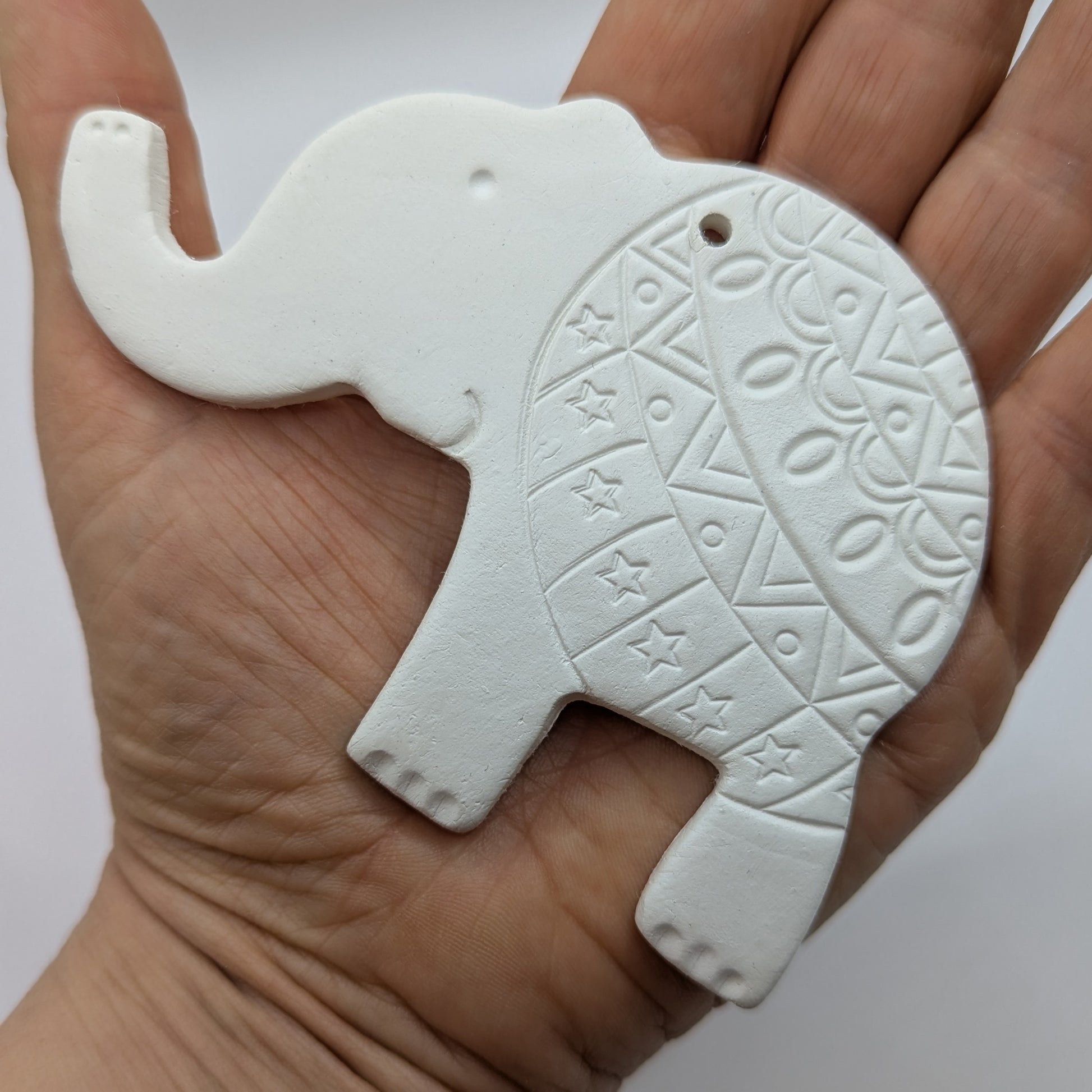 close up of elephant air dried clay decoration in some ones hand to show size
