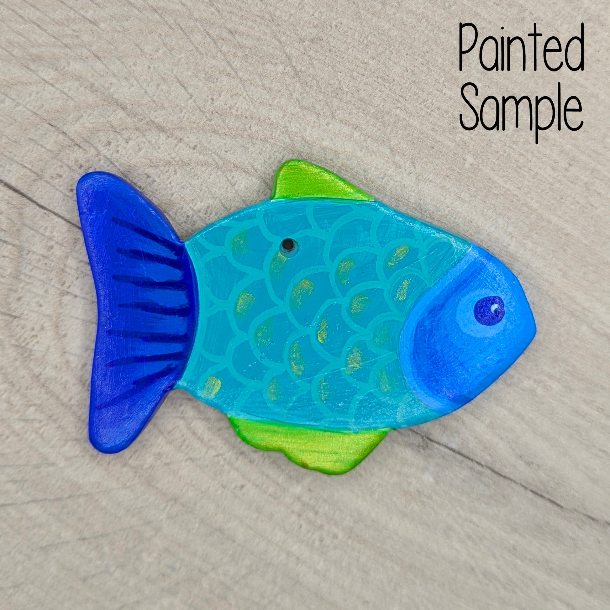 fish painted in blues and greens on a light brown wooden background