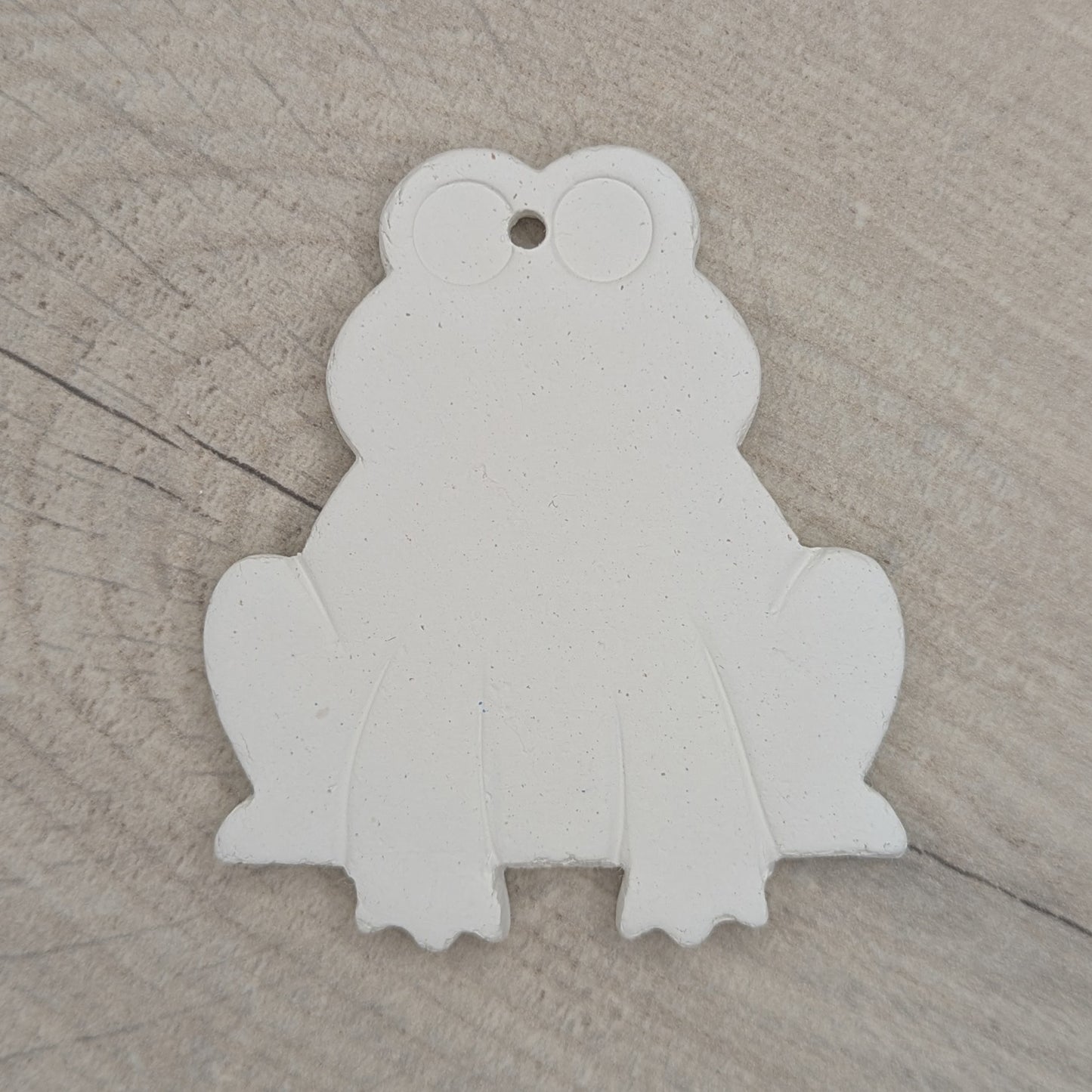 clay frog decoration made of white air dried clay, legs and eyes indented to guide when painting or decorating it