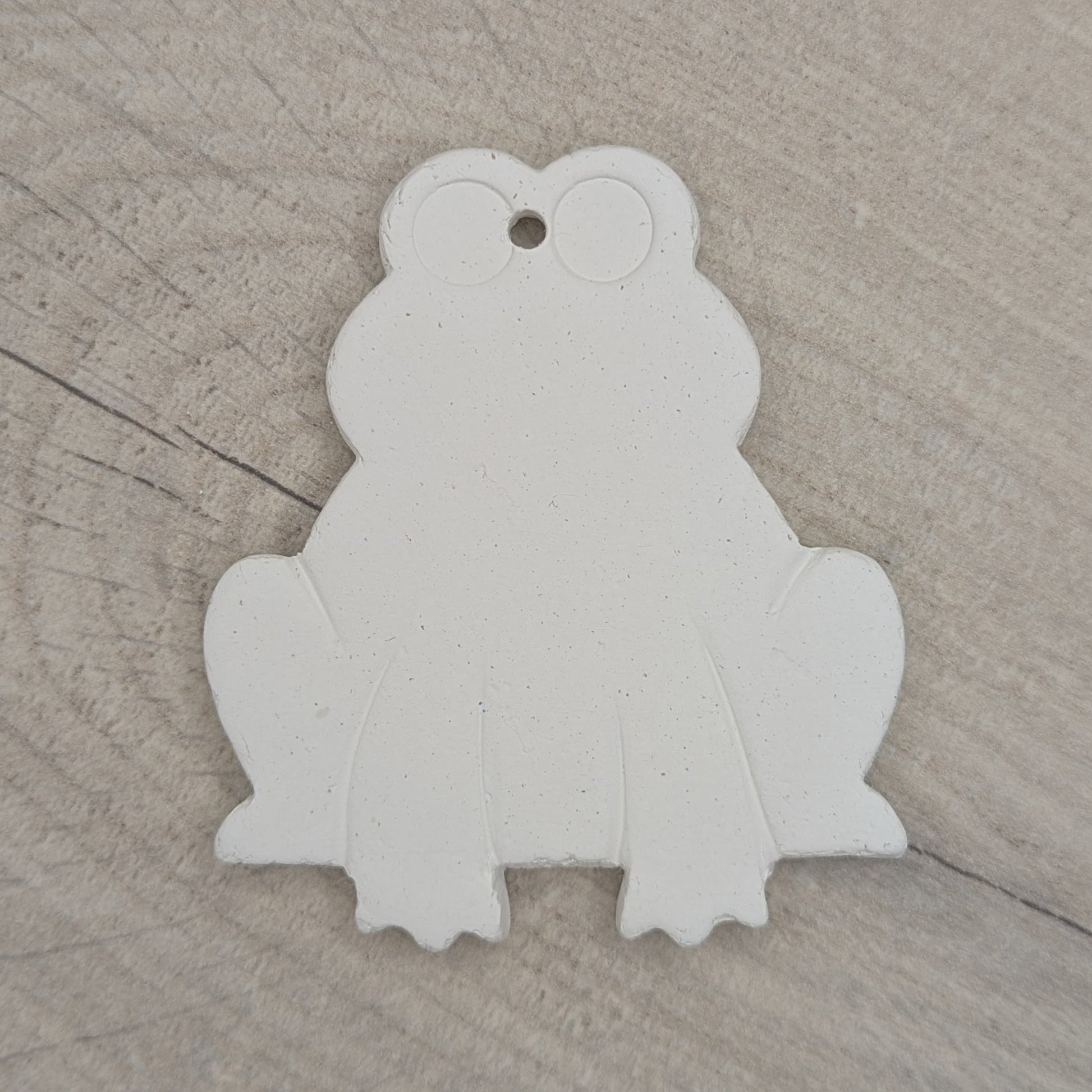 clay frog decoration made of white air dried clay, legs and eyes indented to guide when painting or decorating it