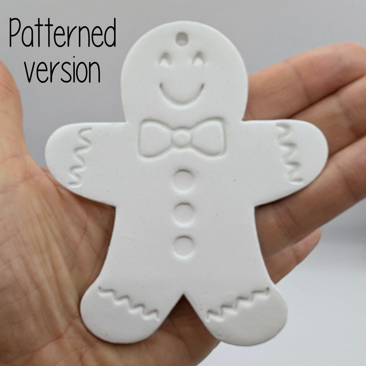 White clay gingerbread man ornament held in a hand with 'Patterned version' text displayed.