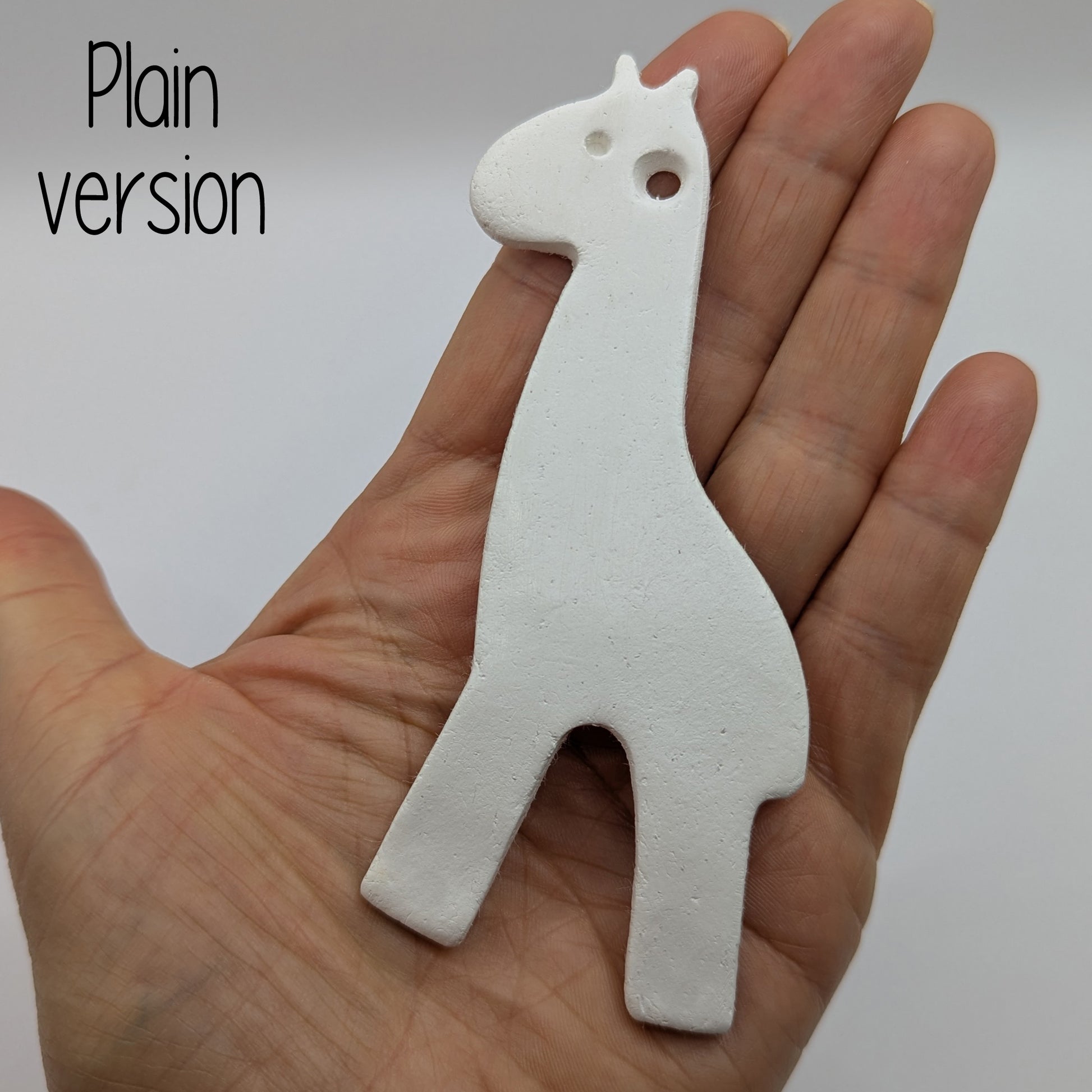 plain air dried clay giraffe decoration in some ones hand to show size