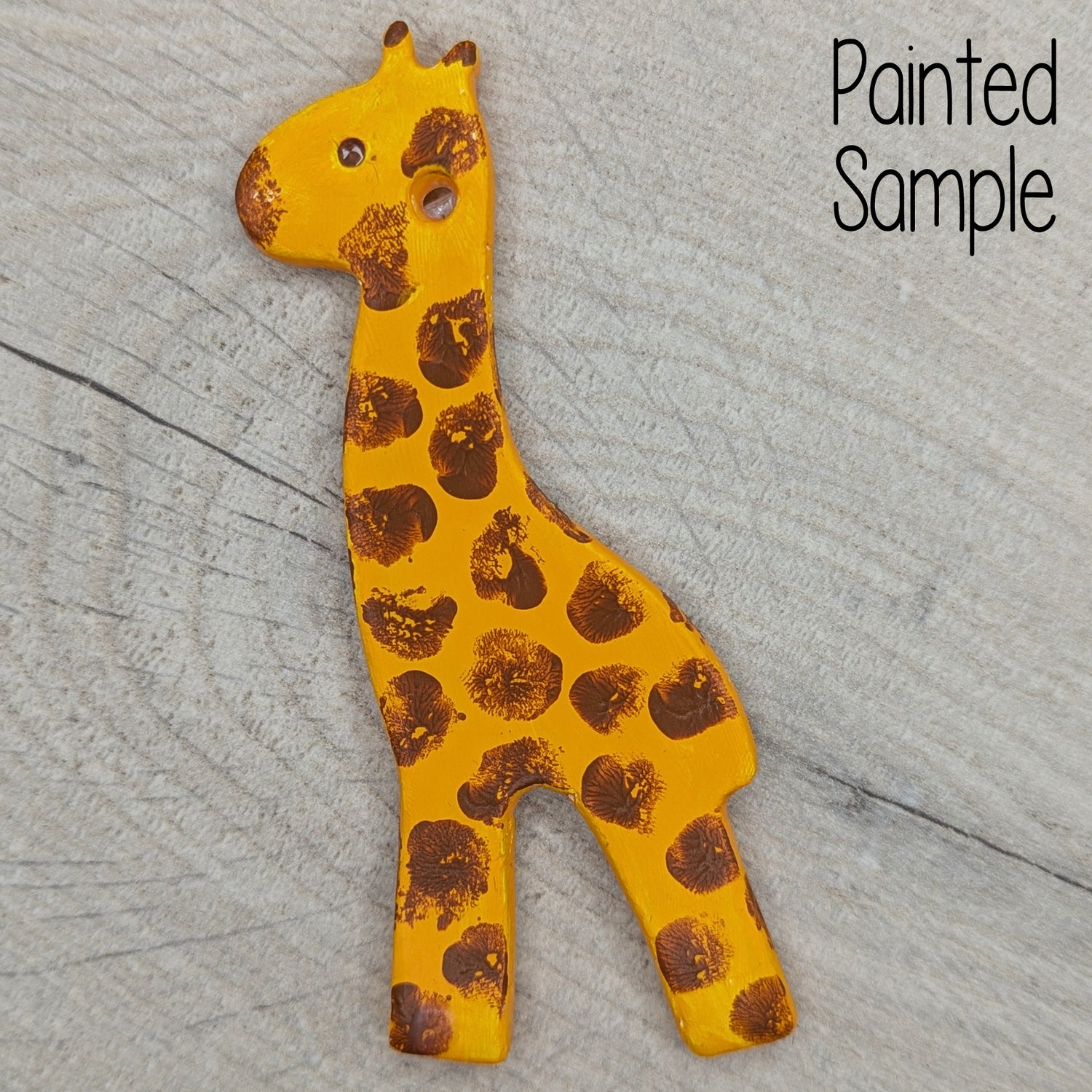 clay giraffe decoration painted in yellow with finger print brown splodges all over