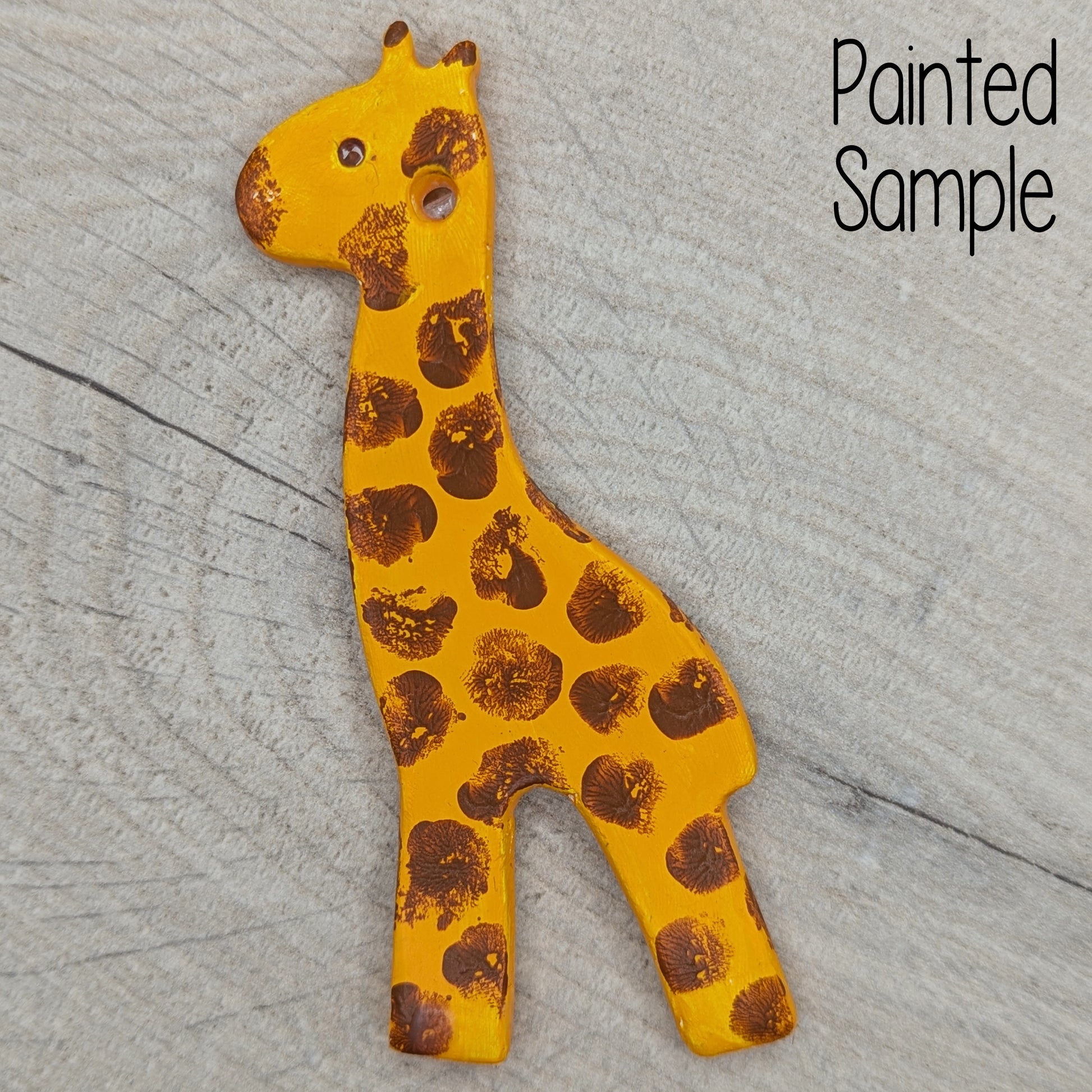 clay giraffe decoration painted in yellow with finger print brown splodges all over