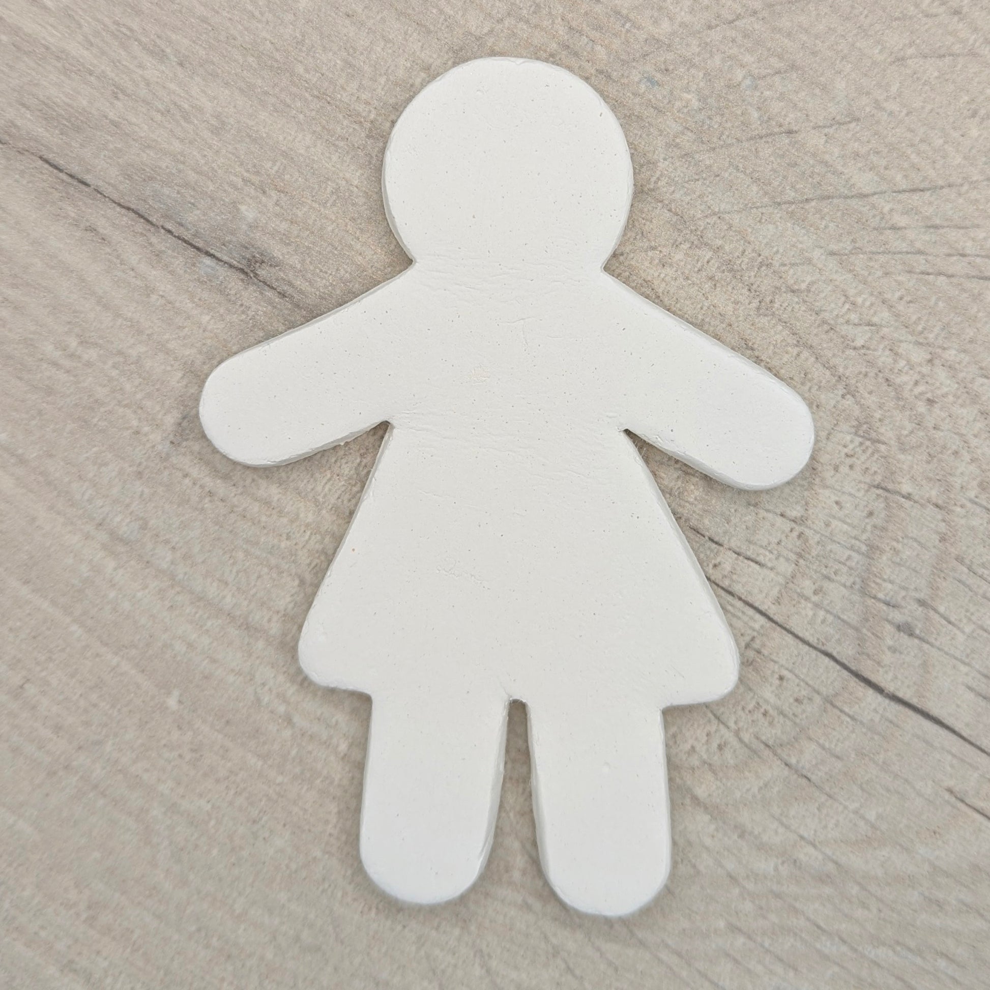 White air dried clay shape on a wooden background
