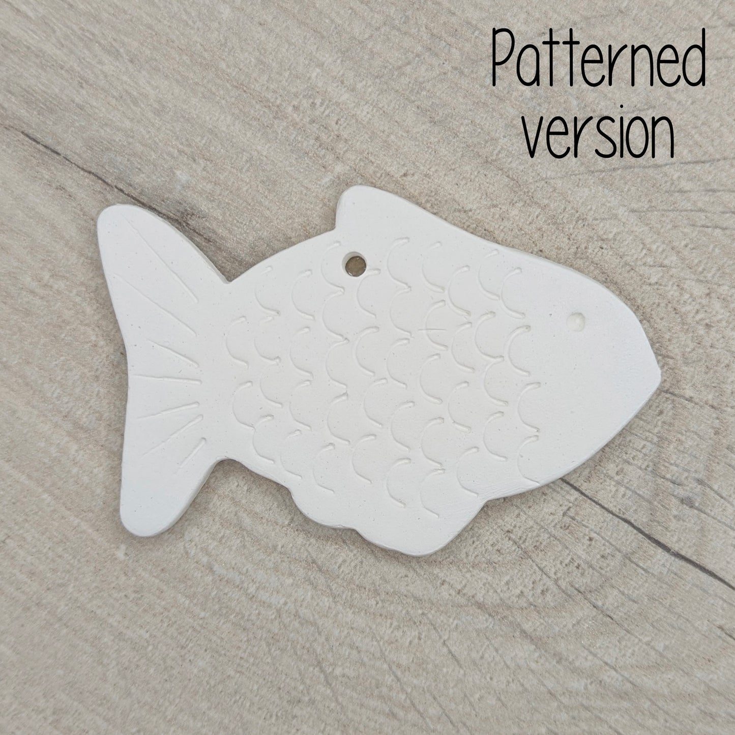 White fish-shaped clay decoration on a wooden surface