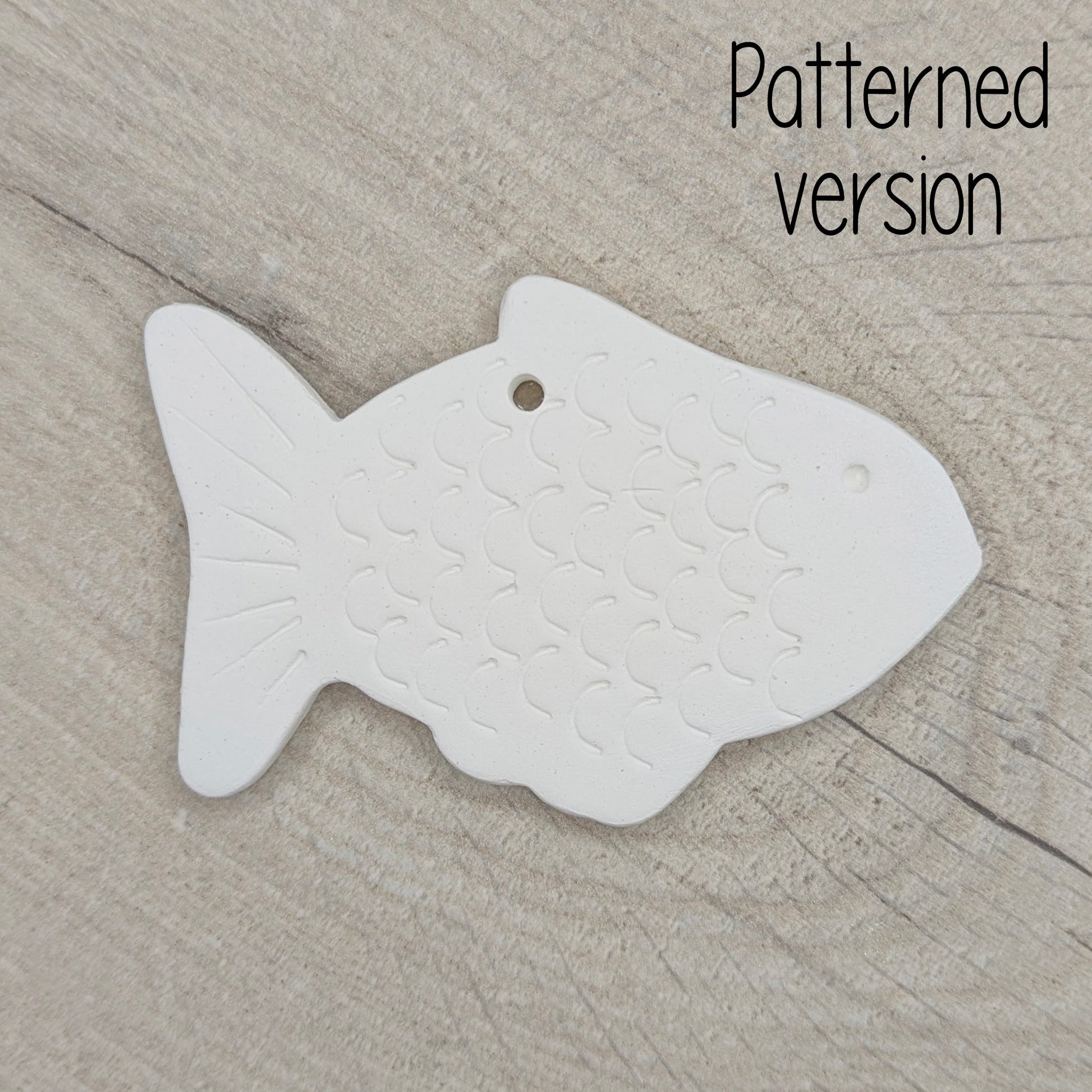 White fish-shaped clay decoration on a wooden surface