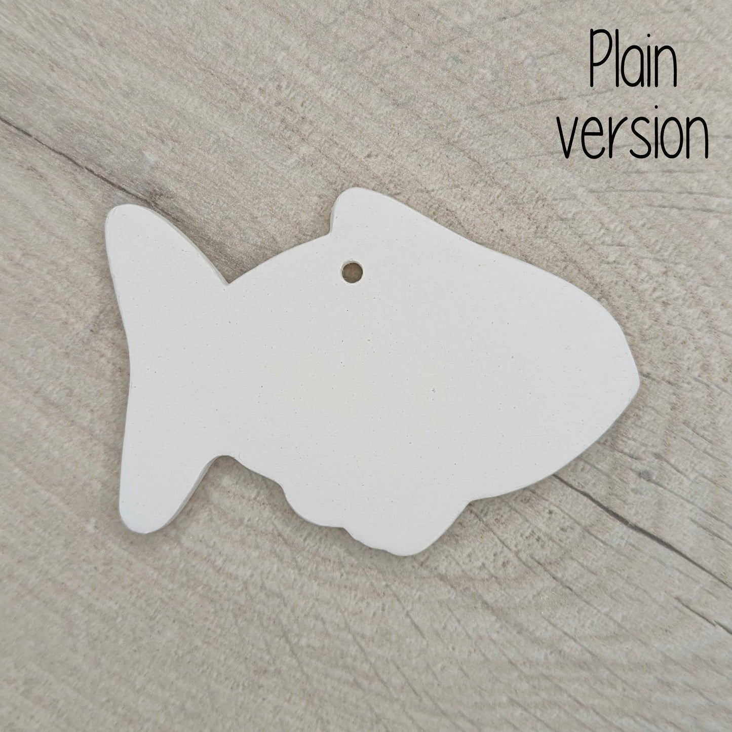 White fish-shaped clay decoration on a wooden surface