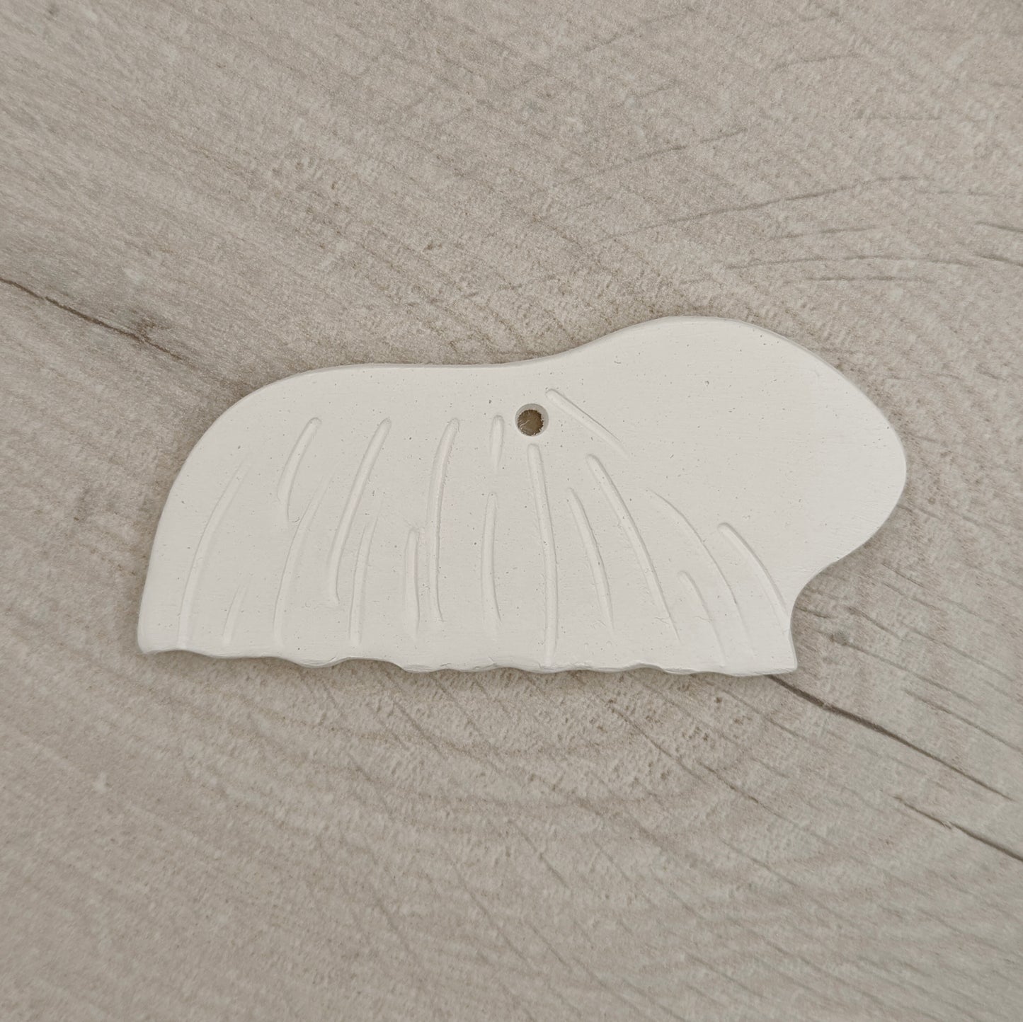 long haired guinea pig clay decoration, on wooden background