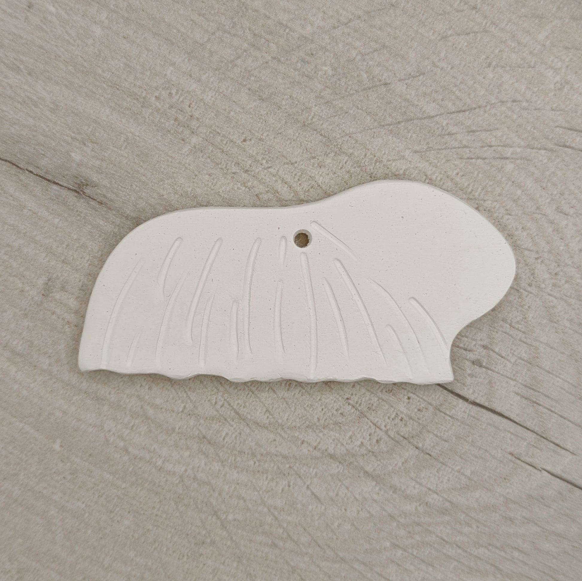 long haired guinea pig clay decoration, on wooden background