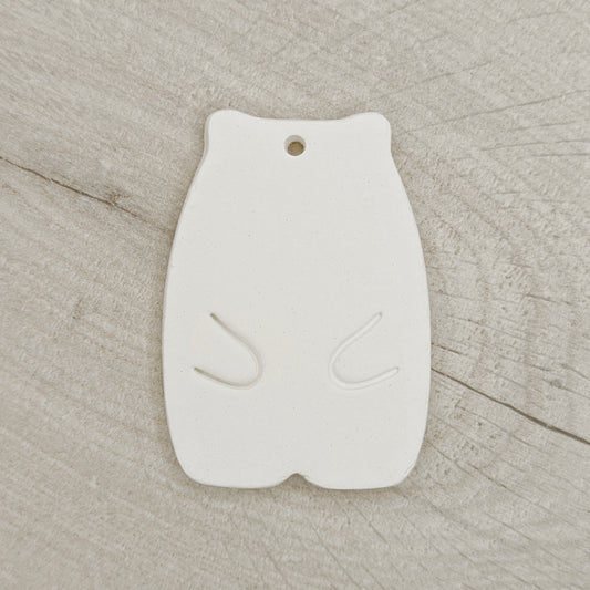 White clay hamster shaped decoration on a wooden background