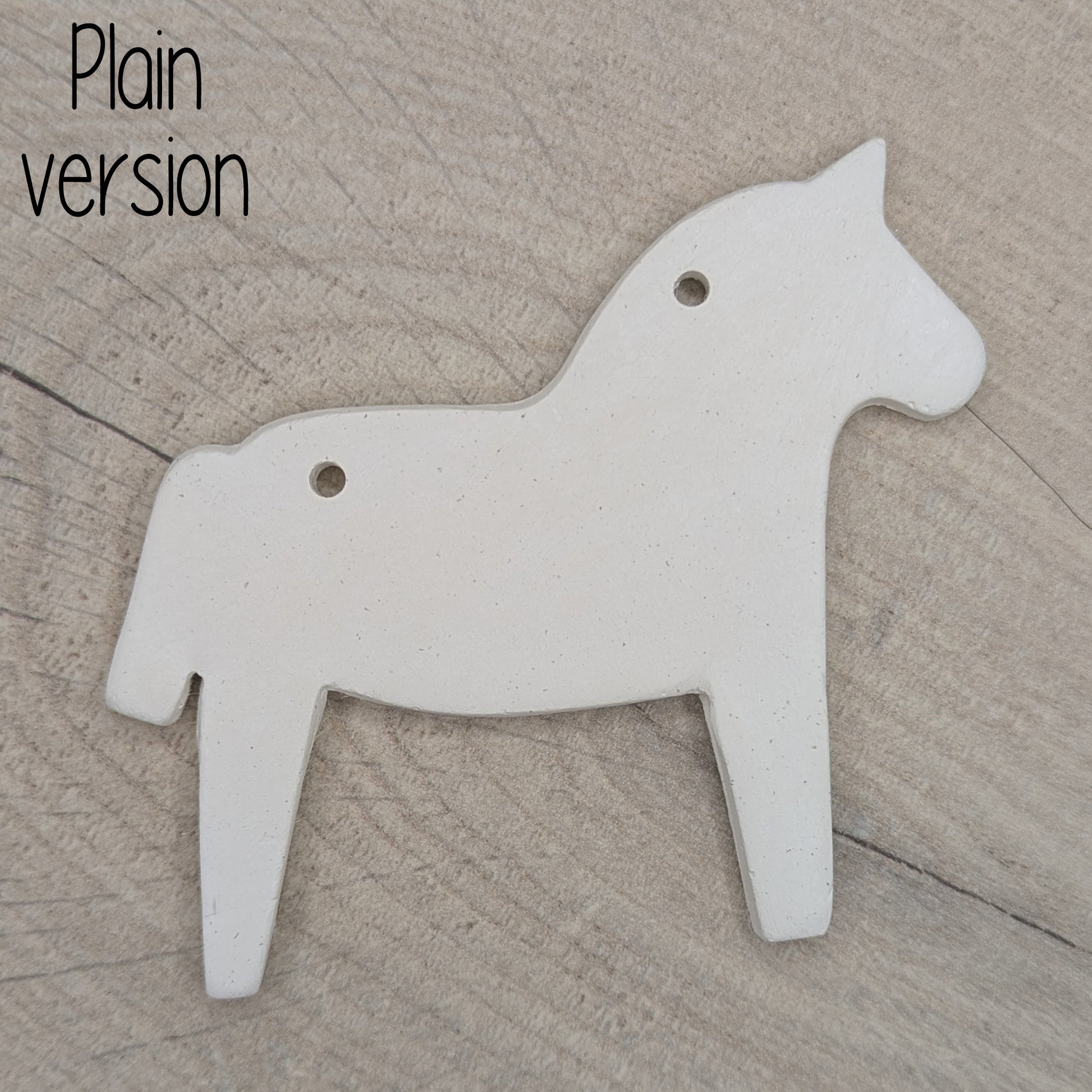 Horse shaped white clay decoration  on a wooden surface, plain version